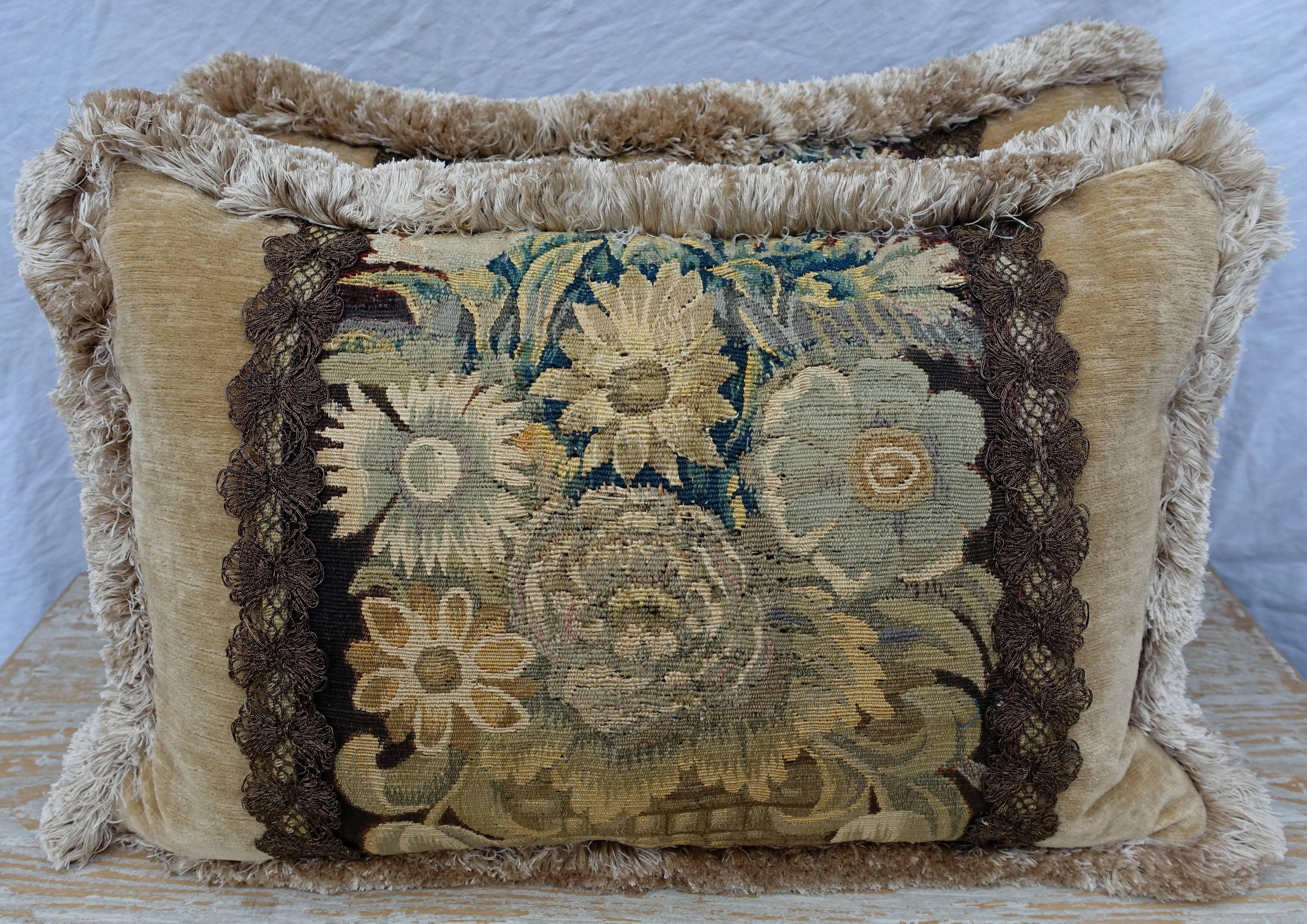A pair of custom tapestry pillows designed by Melissa Levinson and made with 18th century handmade Flemish tapestry combined with a butter colored linen velvet and finished with a cream colored silk trim. 19th century metallic trim flanks either
