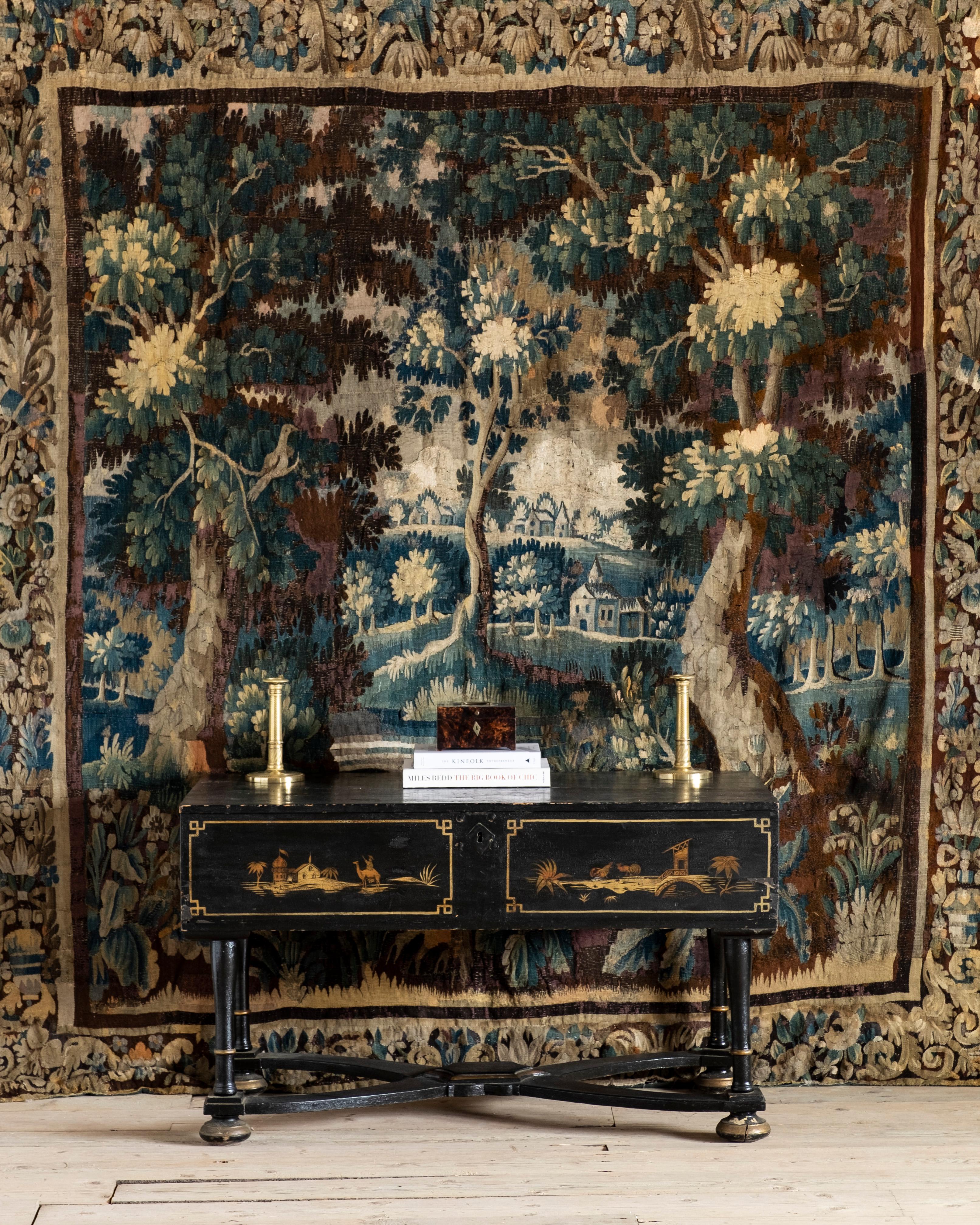 Fine early 18th century Flemish “Verdure” Tapestry finely woven in wool and silk. With trees, plants, houses and a bird in a wooded landscape surrounded by a richly decorated border. Good colors in predominantly blues, greens, and pale yellows,