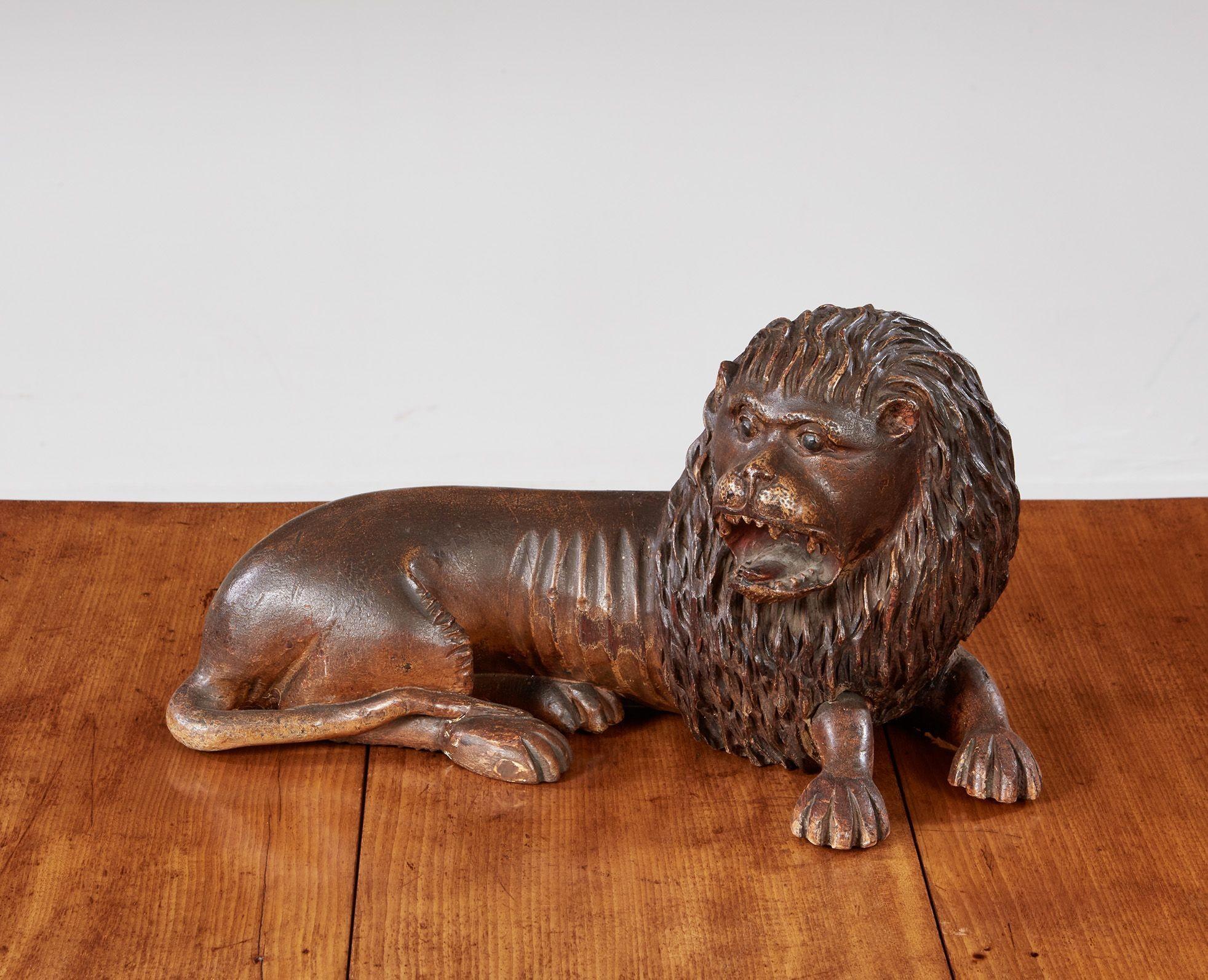 Charming 18th century carved and painted lion in repose, having full mane and growling expression.  Wonderful naive quality and retaining original paint decoration.