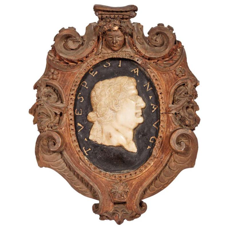 In terracotta with black marble medallion centered by a white marble profile depicting Roman emperor framed by the inscription T. VESPESIAN. A U G .; the terracotta frame with engraved beaded ledge to which a wide band of volutes is applied to frame