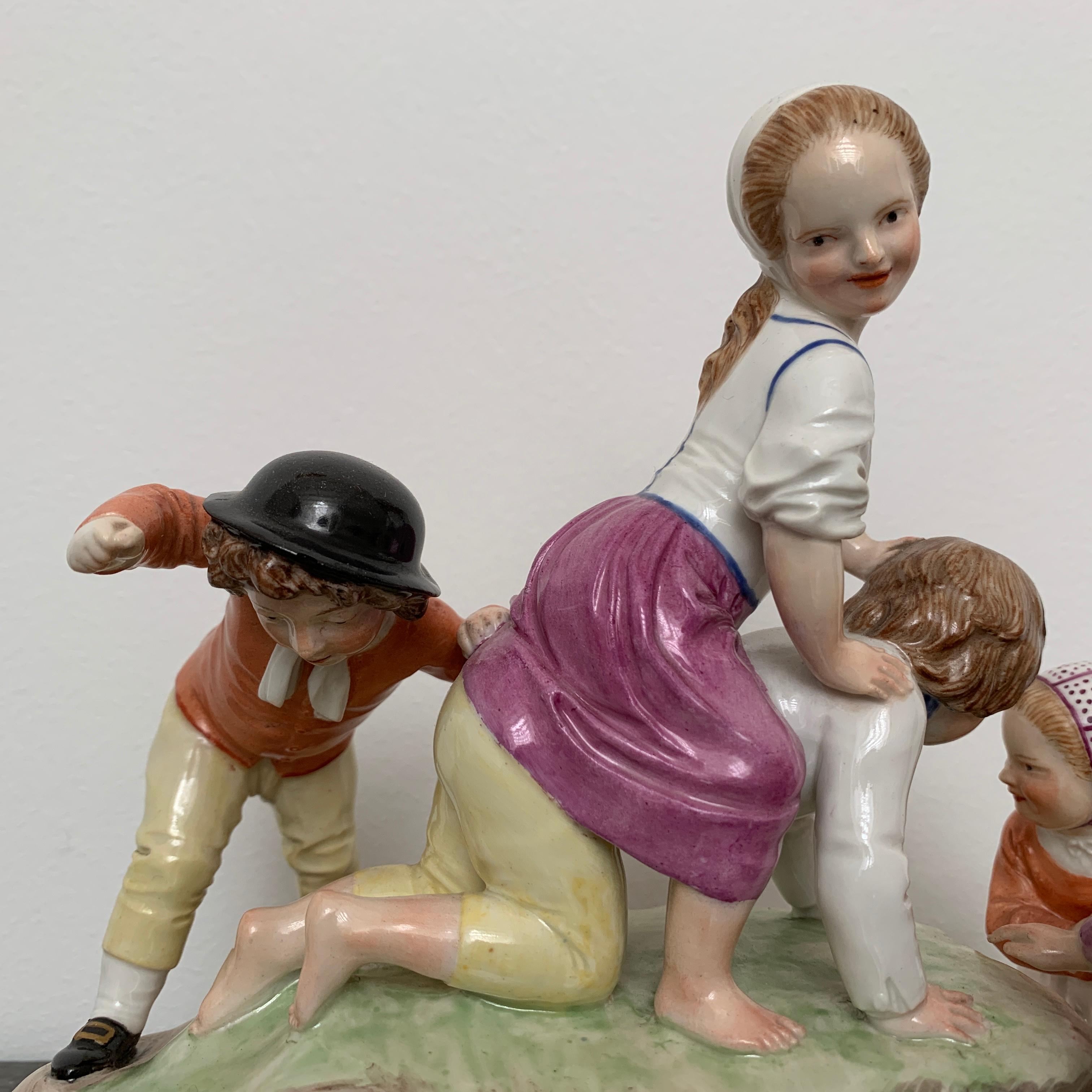 A very amusing figure group modelled by Johann Peter Melchior (1742-1825) in hard-paste porcelain painted in various colours. Composed of five playing children, on an oval rocky mound. The underside with blue crowned CT Monogram and date letter 87.