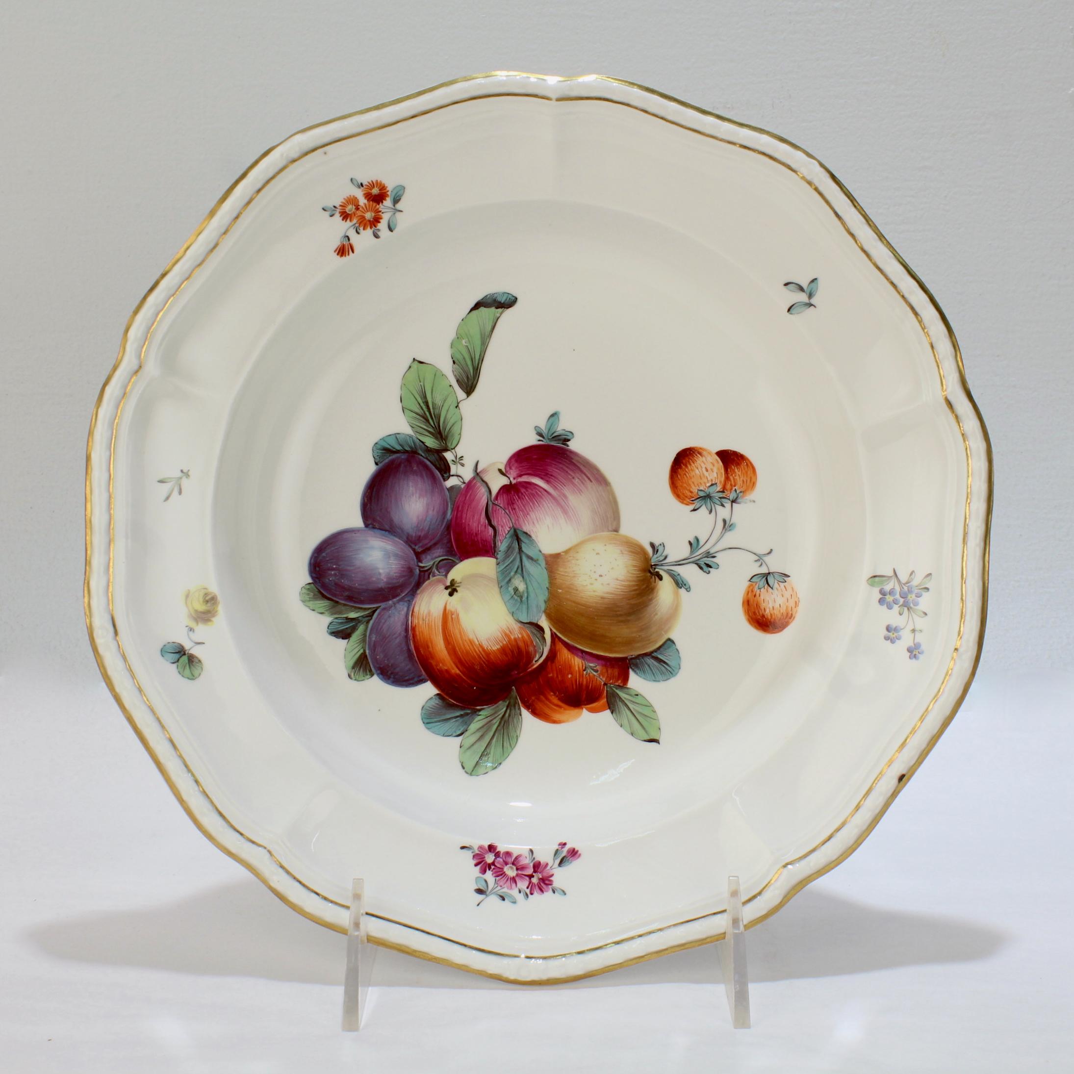 A very fine antique 18th century porcelain bowl.

By Frankenthal during the Carl Theodor period.

With a group of polychrome enamel decorated fruit to the bowl, floral sprays to the border, and a gilt edged, molded rim.

The bowl has black