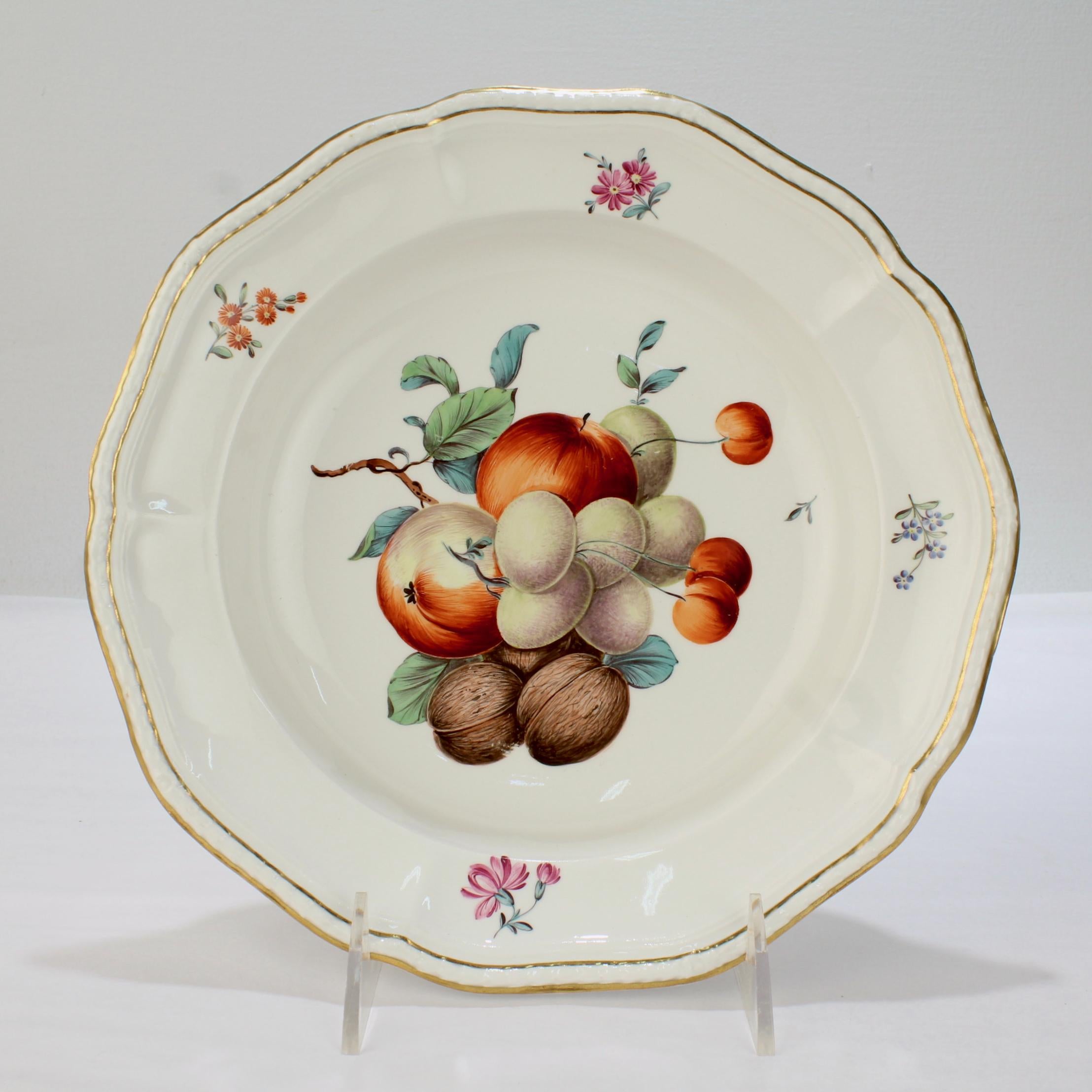 Eine sehr schöne antike Porzellanschale aus dem 18. Jahrhundert.

Von Frankenthal zur Zeit Carl Theodors.

Die Schale ist mit einer Gruppe von Früchten und Nüssen aus polychromem Email verziert, der Rand ist mit Blumenranken verziert und der