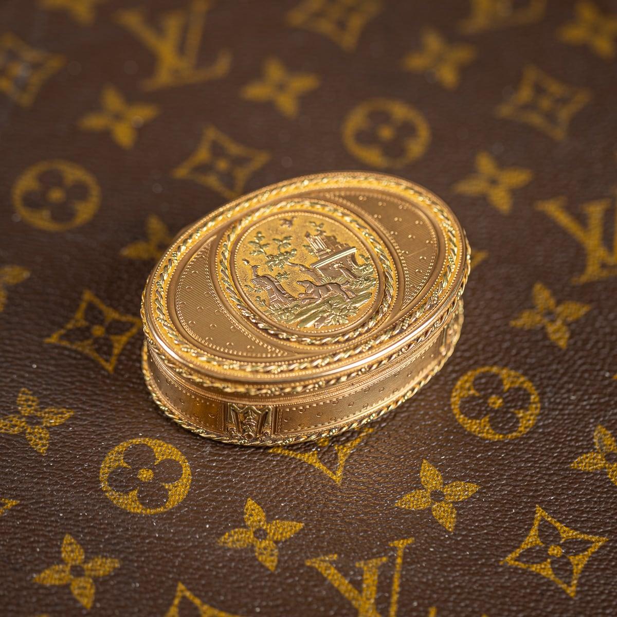 Antique 18th Century French magnificent three-colured 18k gold snuff box, of oval form, the hinged cover with an oval plaque, cast, chased and applied with a dog and a bird within a classical landscape, within a twisted rope border, the sides with