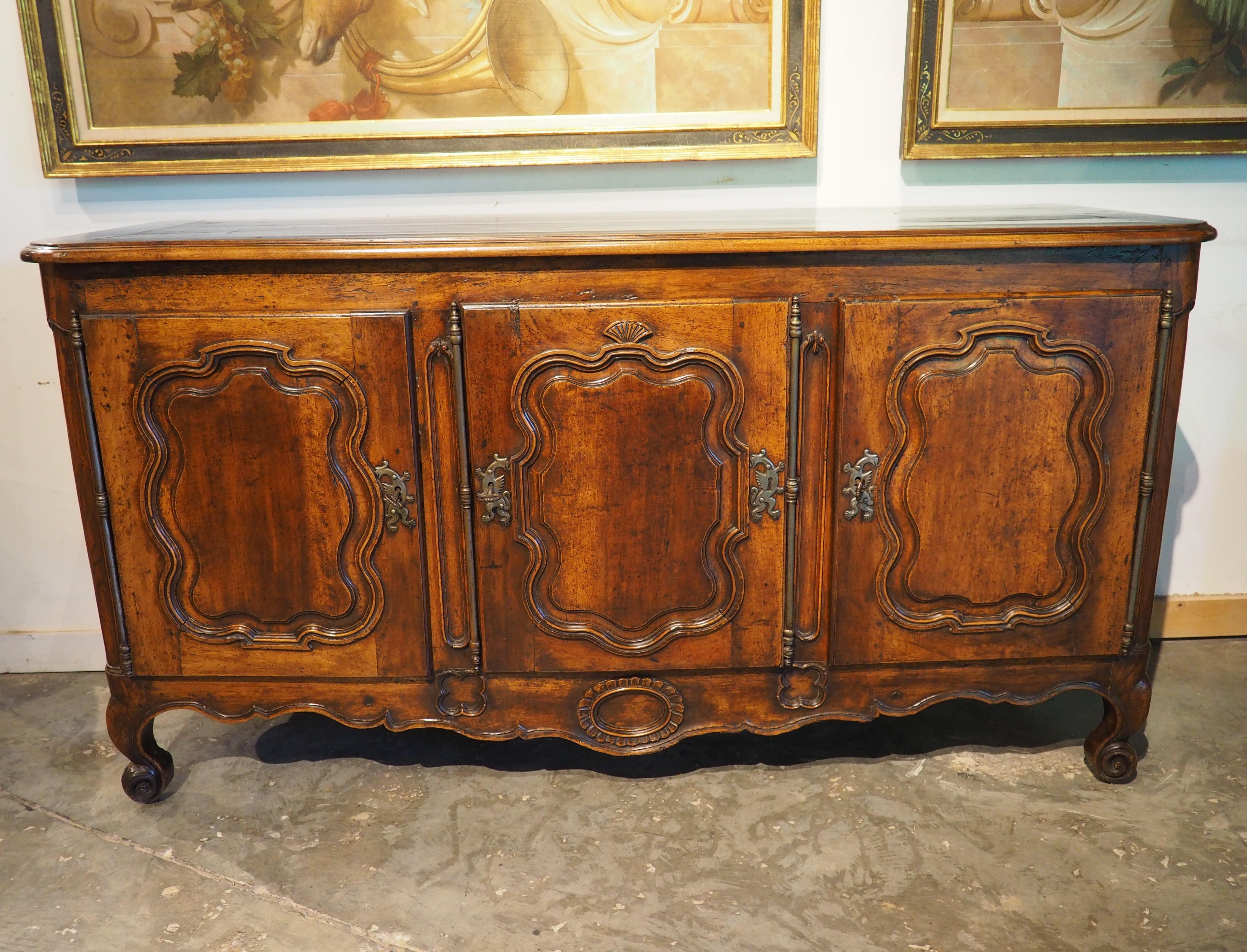 More information coming soon…

A wonderful period piece, dating to the reign of Louis XV (1700s), this hand-carved walnut enfilade features three segregated compartments.  Each door opens on long, iron hinges to reveal a full-length shelf.  The