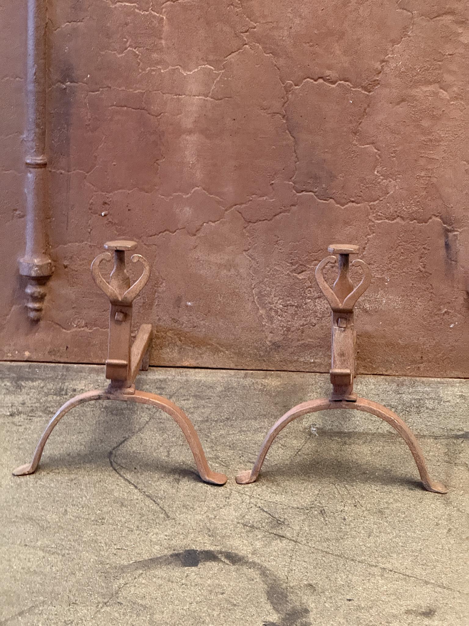 18th century French andirons made of wrought iron. The andirons have decorative spit hooks to grill food. The condition is good. Period Louis XV.