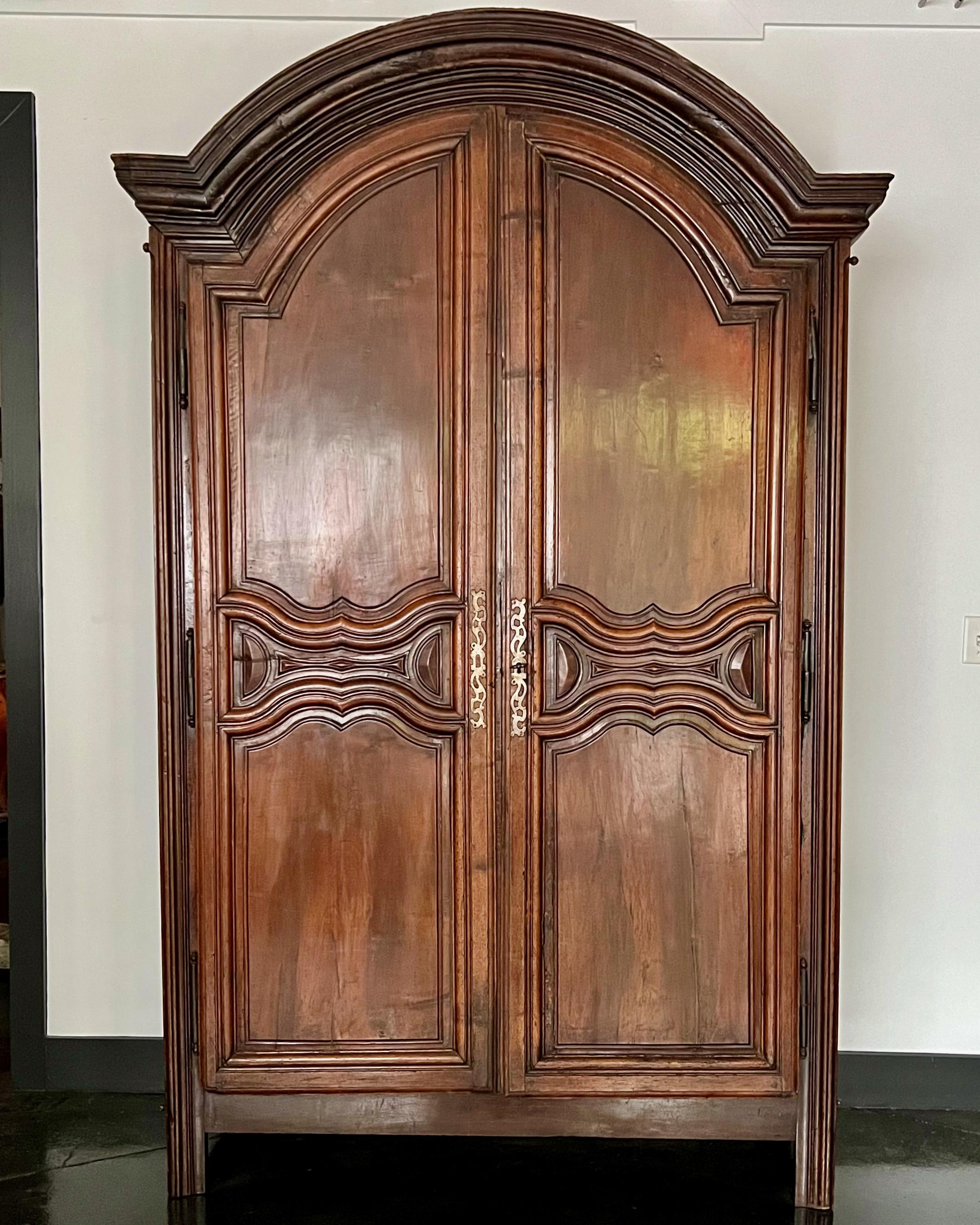 18th Century French walnut armoire with doors strongly moulded in many curves and counter-curves. The “chapeau de gendarme” cornice richly carved follows curves in all 3 dimensions. Beautiful ironwork with large hinges and original lock.
France ca
