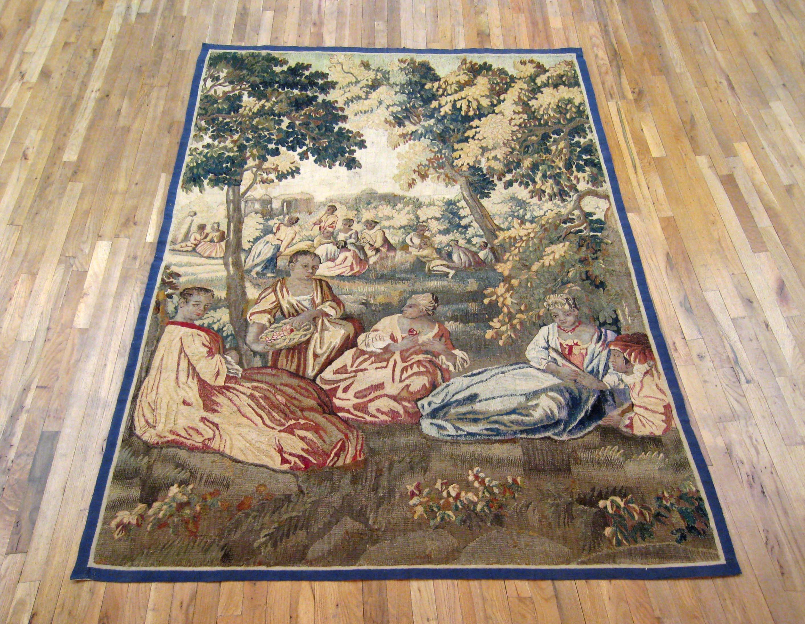 A French Aubusson Pastoral tapestry panel from the 18th century, featuring several women in the foreground, and many more in the background, tending to their daily chores while seated in the lush grassy field of an expansive estate, with various