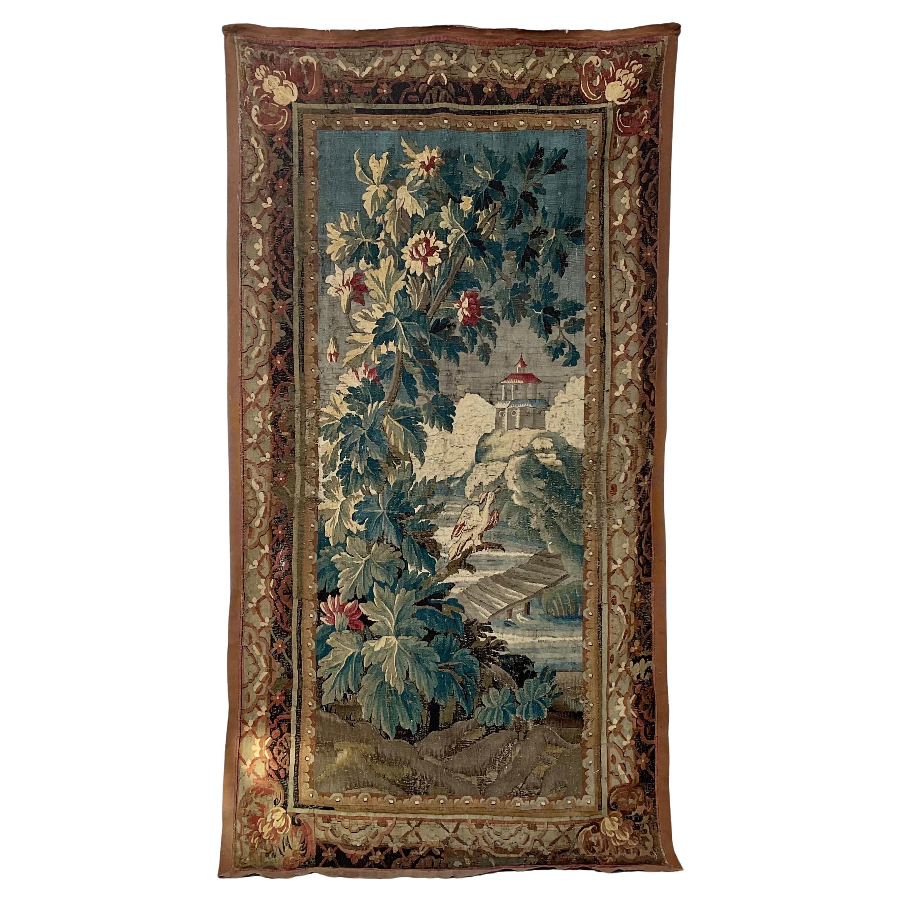 An antique 18th century handwoven French tapestry. 
This beautiful antique tapestry was woven in Aubusson, France, circa 1760. Rectangular in shape, the colorful piece depicts an outdoor scene with a large bird in the center, a bridge leading to