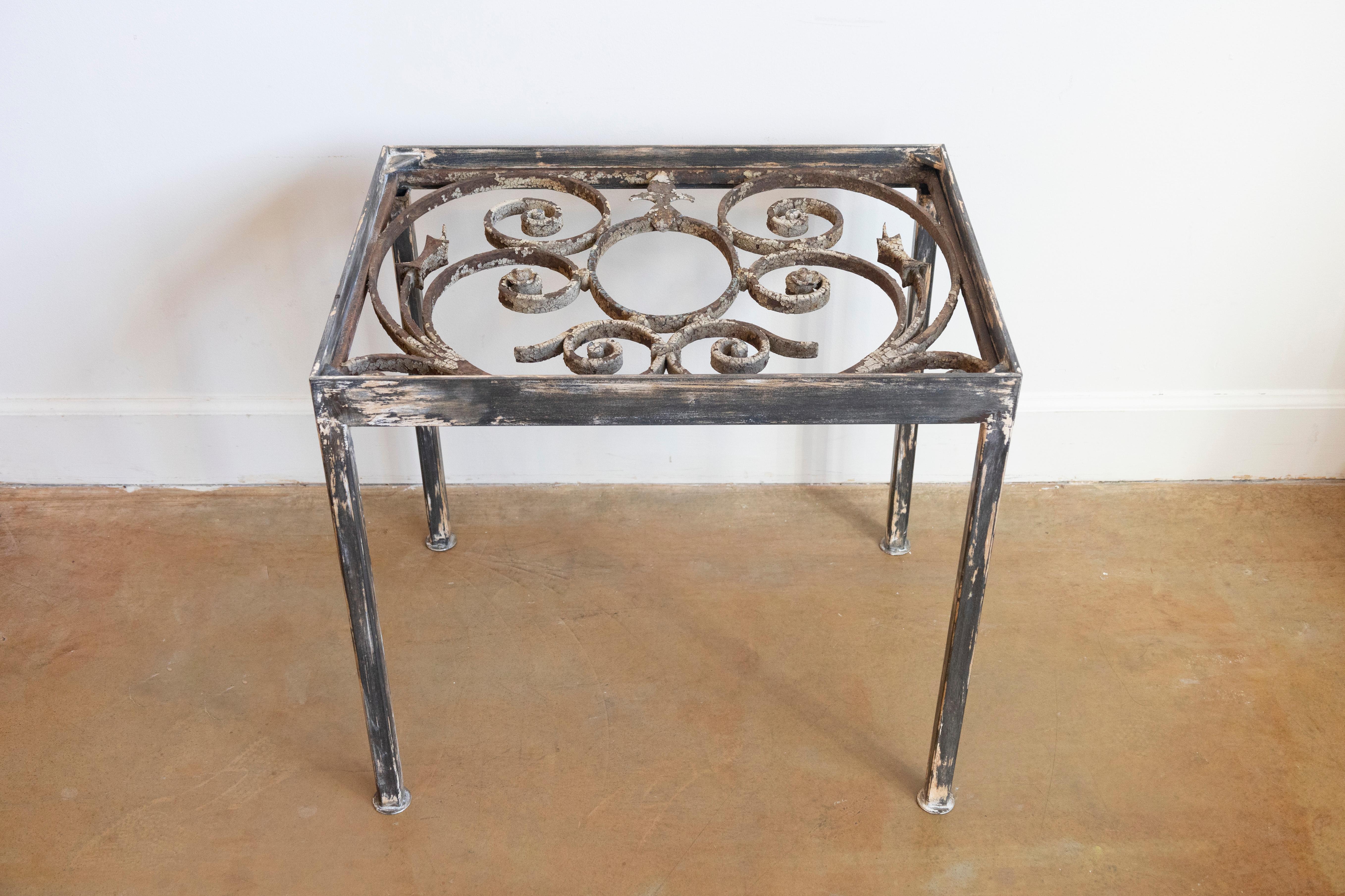 Cette table basse unique est fabriquée à partir d'un élément de balcon en fer forgé français du XVIIIe siècle, reconverti en une pièce étonnante et fonctionnelle. Les ferronneries ornées de la table présentent des motifs de volutes complexes,