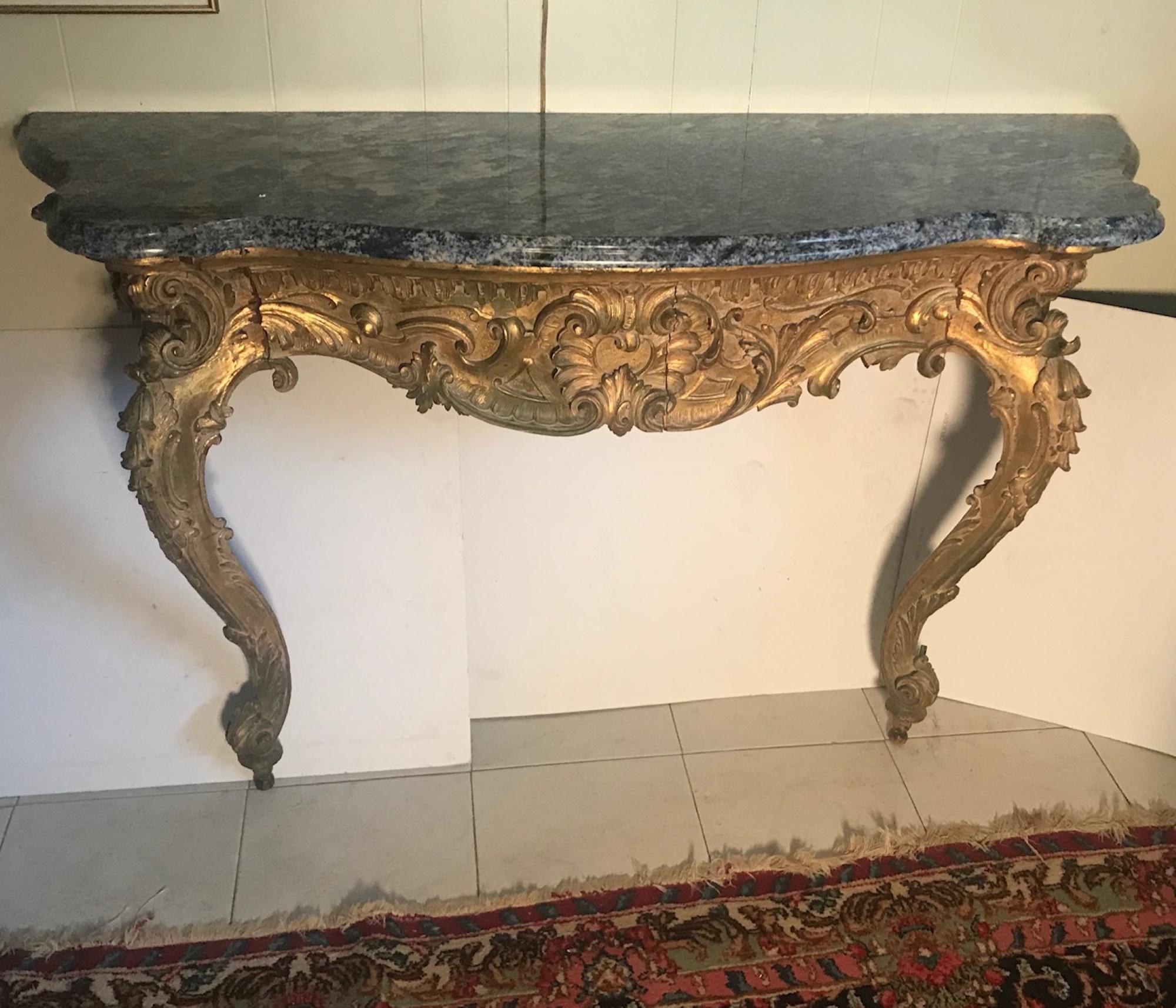 Antique 18th century French Baroque carved giltwood and marble console, circa 1790

This magnificent and elegant denim lapis marble granite top console table is beautifully carved from mahogany wood and gilded. The console is raised on two thick