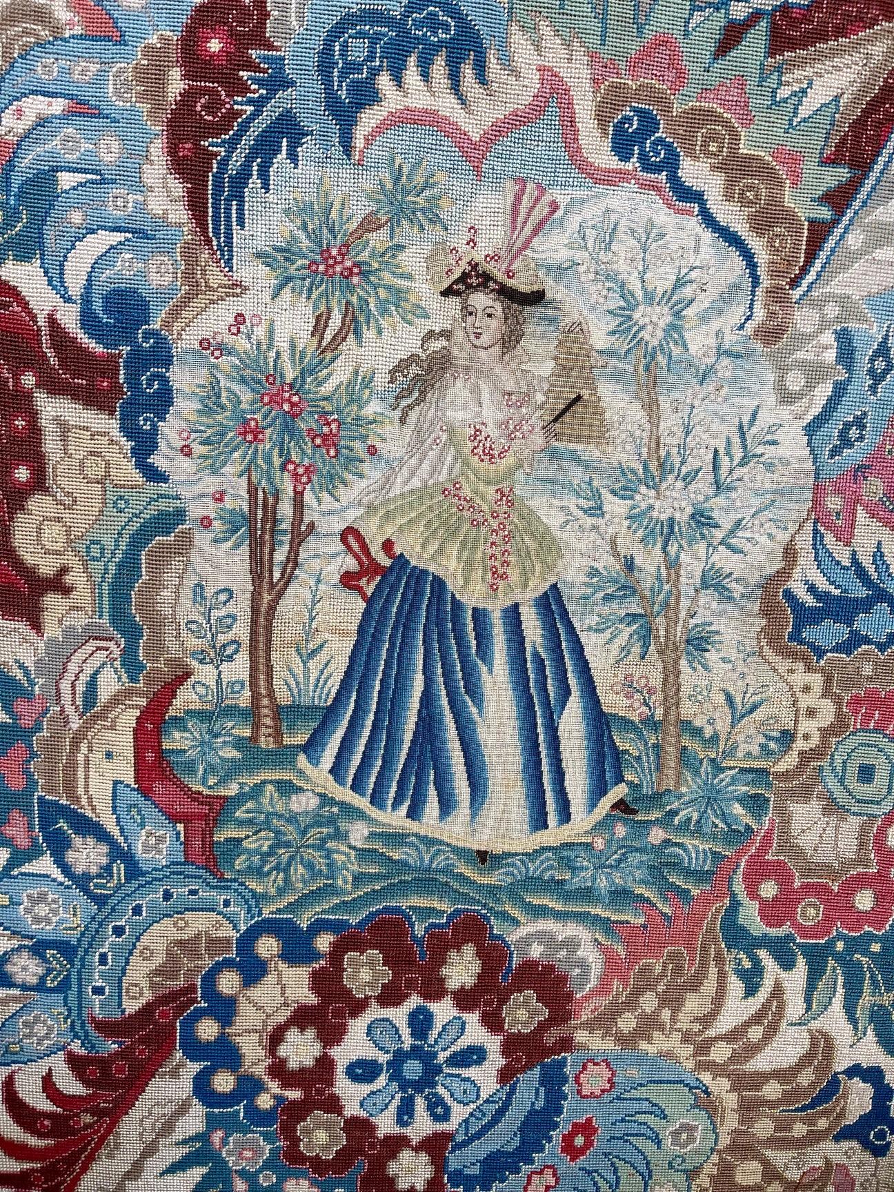 Panel de aguja de principios del siglo XVIII (hacia 1720) trabajado en hilos de lana y seda, con una figura femenina central tocando un instrumento musical entre árboles frutales y en flor, todo ello trabajado en petit-point.

Contra una maravillosa