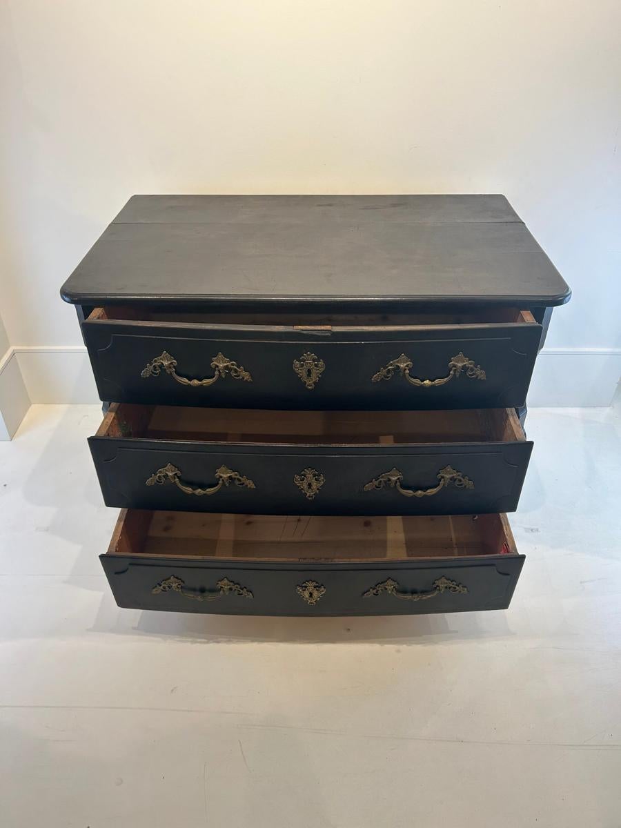 This exquisite 18th Century French Regence chest is a magnificent example of the elegant and opulent design characteristic of the Regence period. The chest is finished in a deep, rich black, which serves as a striking contrast to the ornate gilt