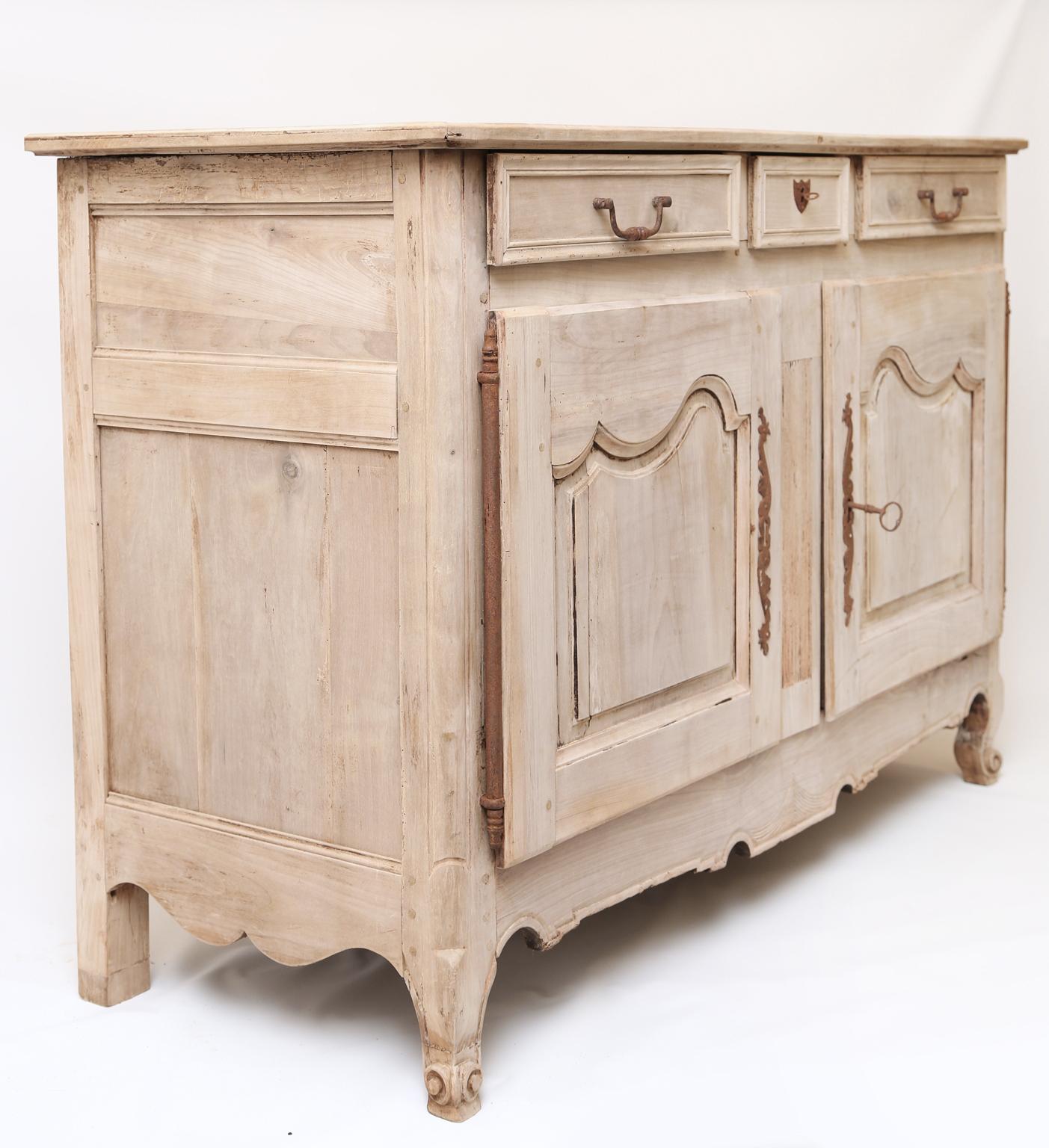 Credenza buffet cabinet, of bleached walnut, in the Provençal, having a molded rectangular top, over apron of three drawers, double cupboard doors open on iron hinges, shaped apron raised on cabriole legs, ending in snail toes. 

Stock ID: D1602.