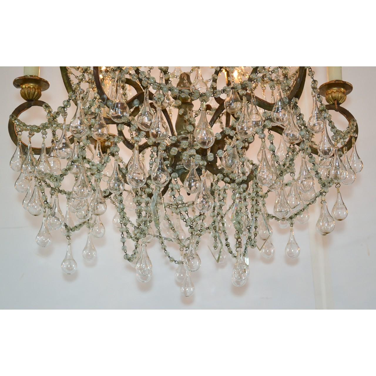 Very elegant 18th century French chandelier with elaborately scrolled gilt bronze arms draped with cascades of cut crystal beads. Accented overall with superb blown glass teardrops. Beautiful foliate motif bronze candle cups,

circa 1780.