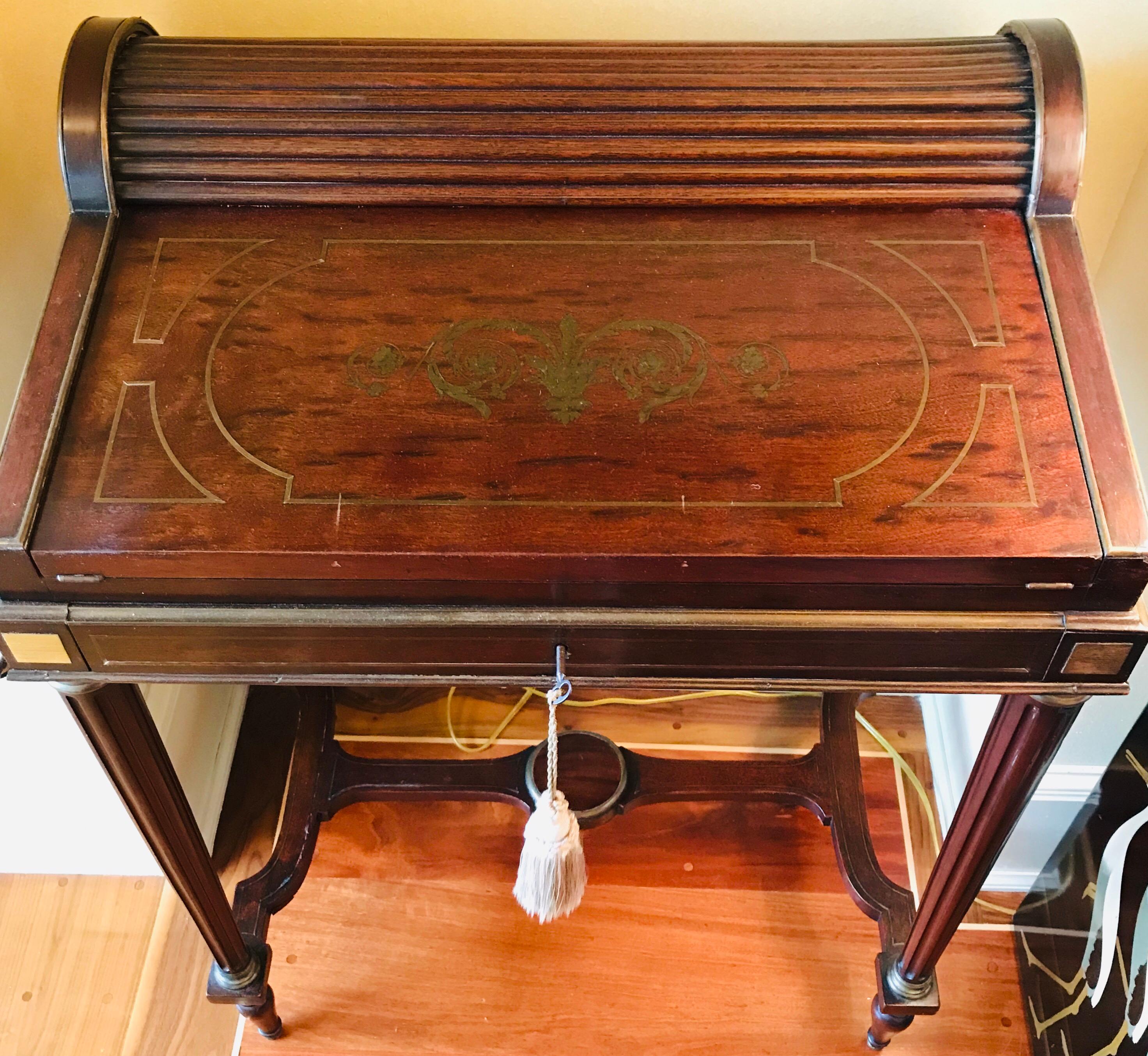 Exquisitely detailed late 18th century French rosewood Campaign style writing desk, inlaid with brass arabesque scroll work and enhanced with brass fittings joining the legs to the body legs and applied to the feet. This museum-worthy piece has a