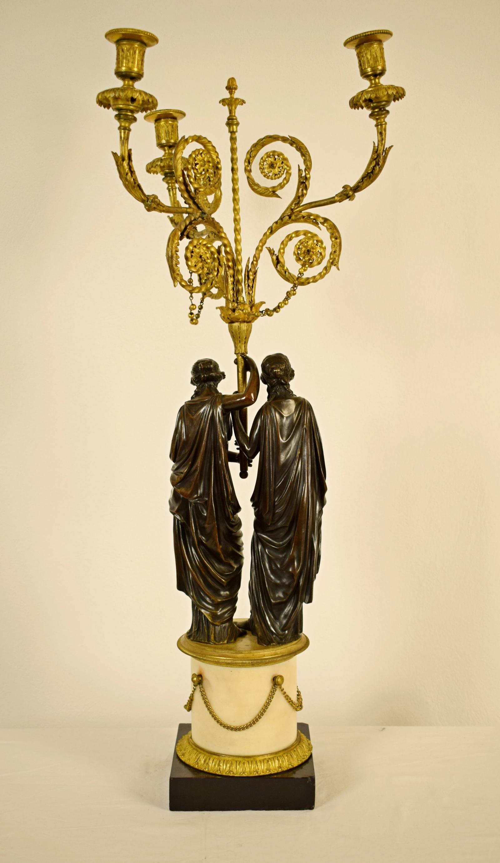 18th century, French bronze three-light candelabra with female figures

This three-light candelabra is made of patinated and gilt bronze. It was made in France in the 18th Century. It’s composed of a group of two magnificent young women dressed in