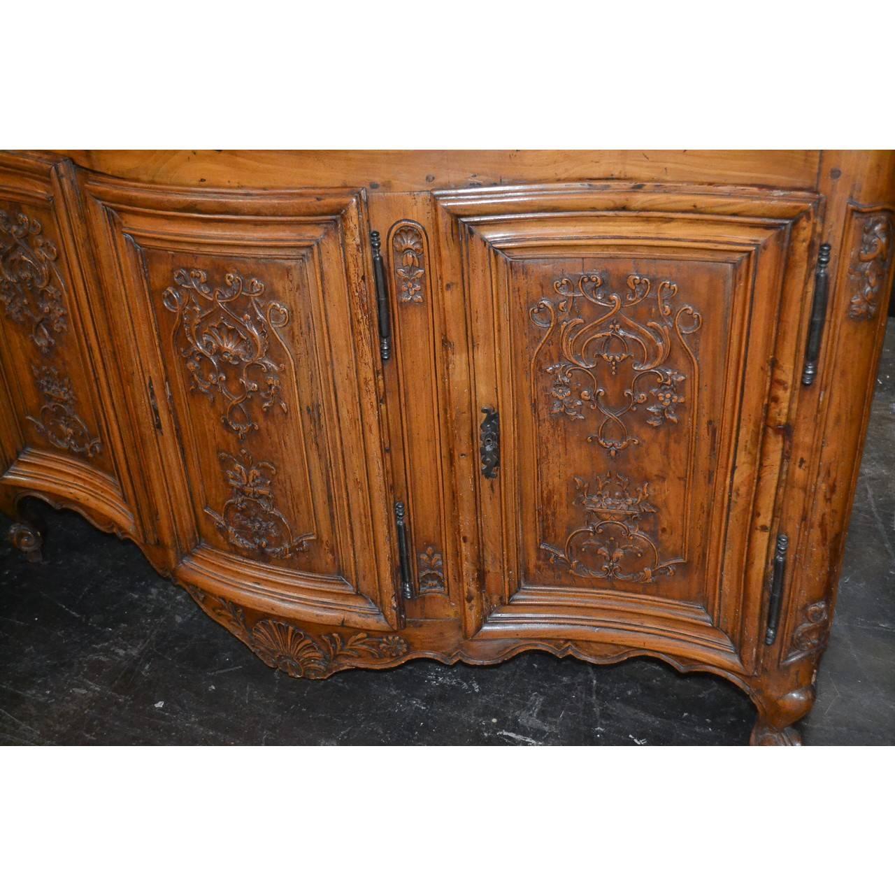 Fabulous 18th century French serpentine fronted buffet or server from Provence, crafted of chestnut with a finely aged patina. The three cupboard doors and shaped skirt with outstanding relief carvings depicting shells, stylized vines and leaves,