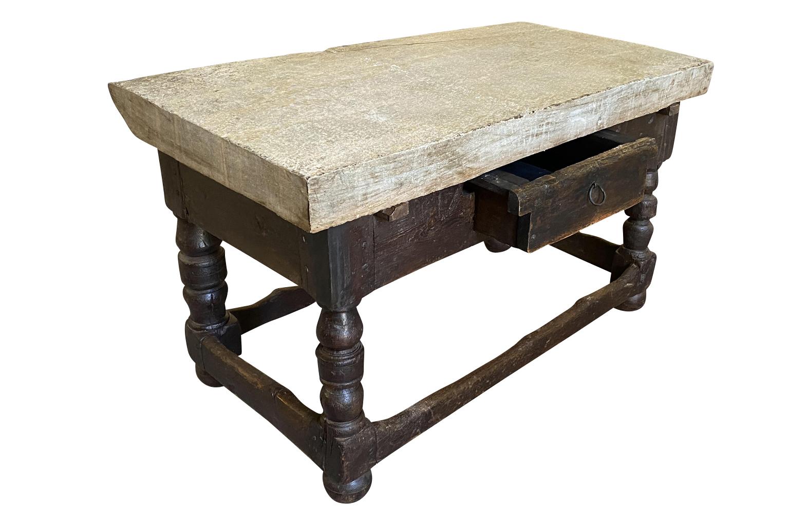 A very handsome 18th century French Butcher table. Beautifully constructed from richly stained oak with a single drawer and nicely turned legs topped with a very thick piece of stone. Wonderful as a kitchen island, work table in a potting shed or a