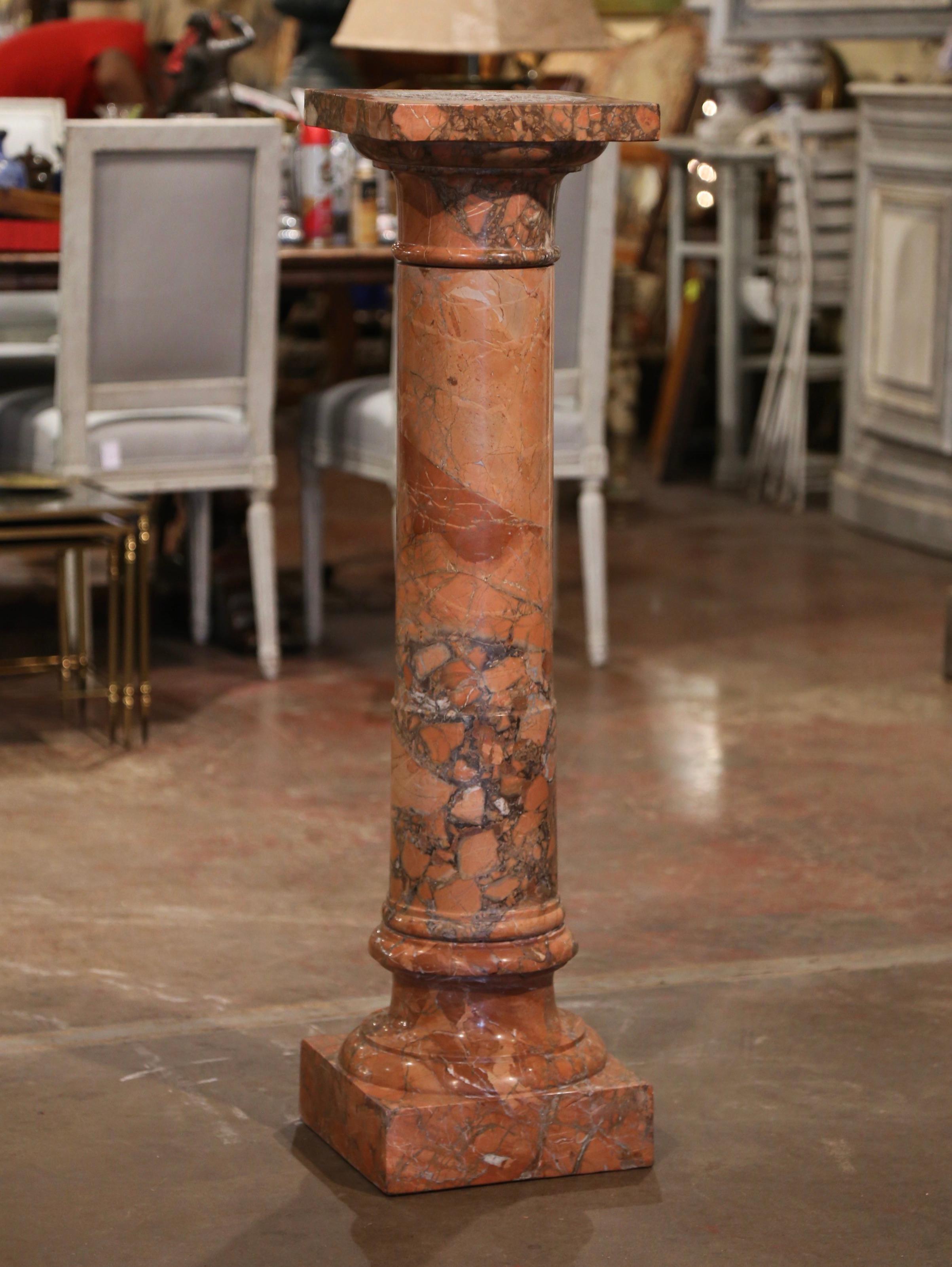 This elegant antique pedestal was crafted in France, circa 1780. Hand carved of rare variegated rust marble, the display piece stands on a sturdy square plinth base over a round and slightly tapered stem embellished with carved decor throughout. The