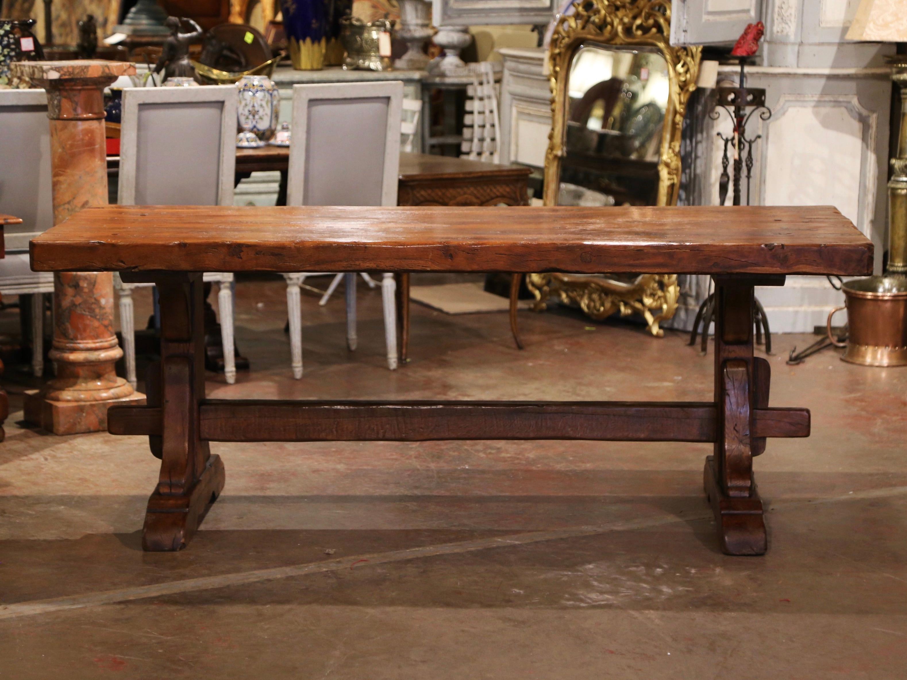 This elegant antique dining table was found in a monastery in Normandy. Crafted in France circa 1780 and built of solid oak, the table stands on two carved legs ending with shoe base, and joined by bottom stretcher attached with key and tenon. The