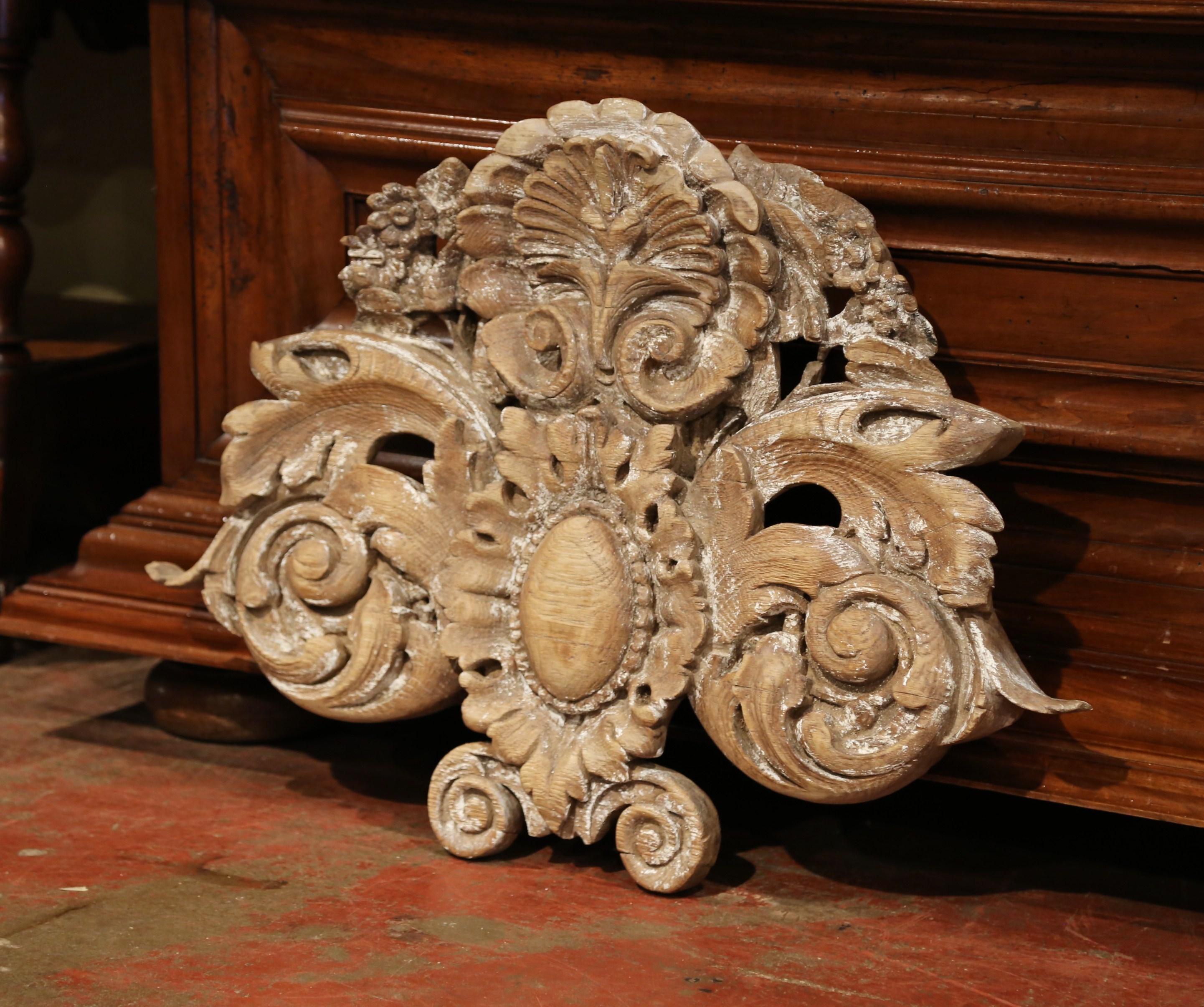 Place this important carving over a mantel; half circle in shape, and hand carved in Normandy, France, circa 1780, the Louis XV wall hanging sculpture features a large shell motif at the pediment flanked with scroll foliage decor on both sides and