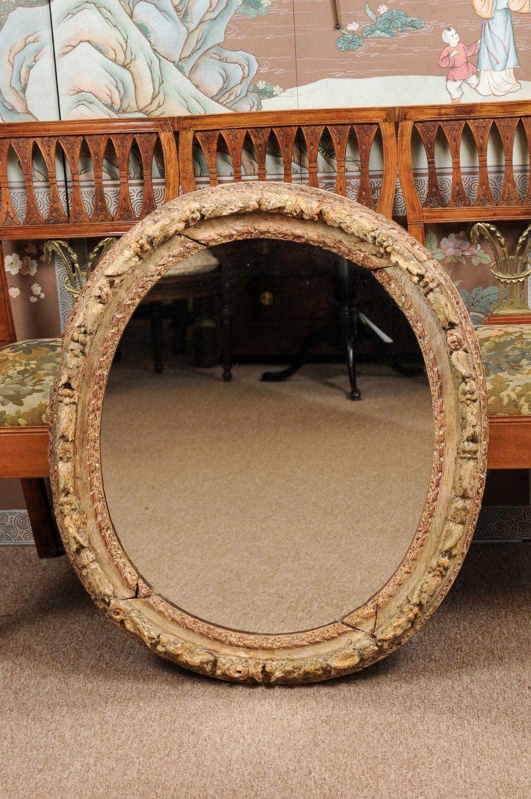 18th century France carved wood oval-shaped frame in painted finish fitted with new mirror plate.