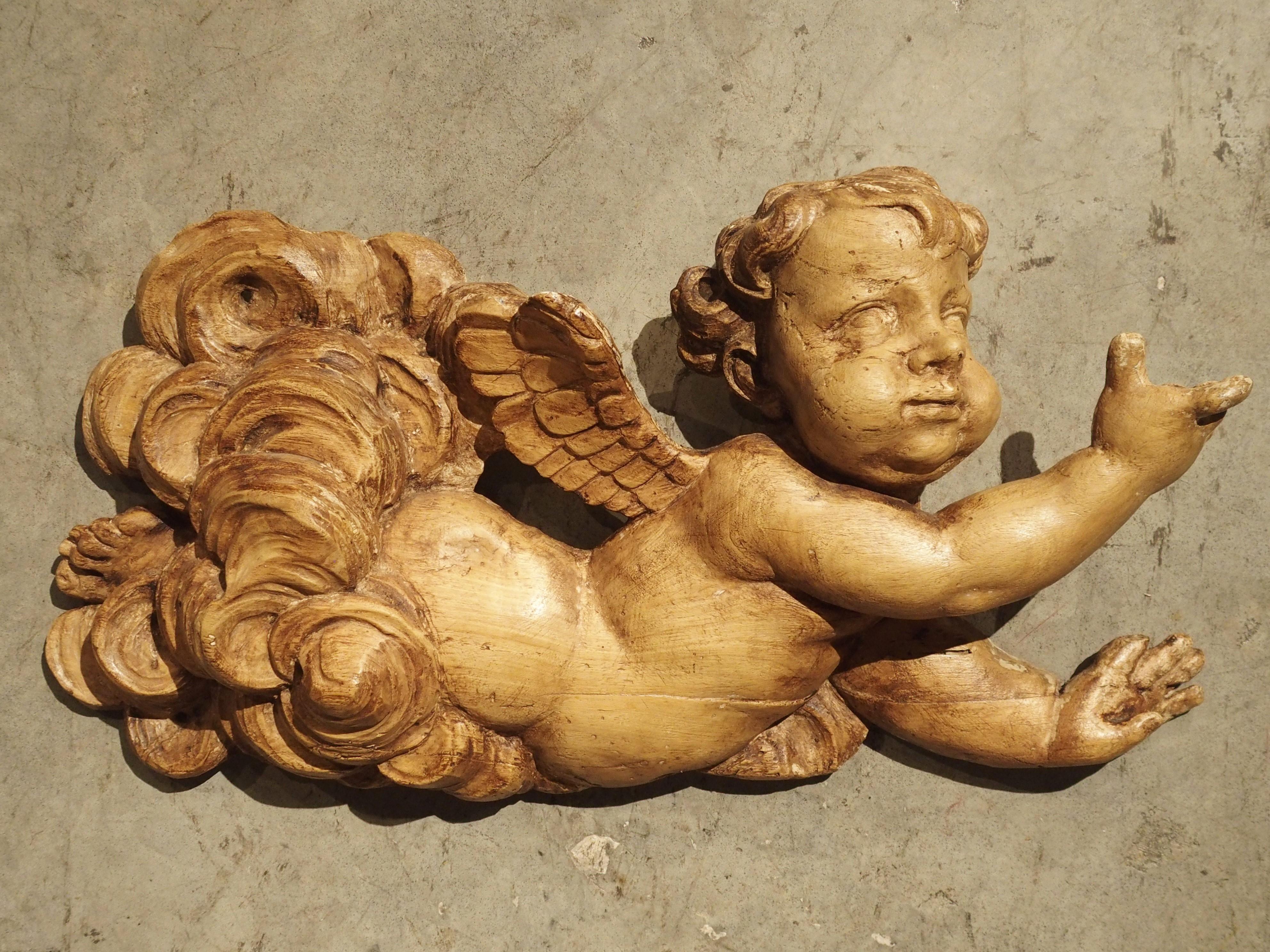 Diese leichte und kunstvoll geschnitzte Skulptur stellt einen kleinen, geflügelten Cherub dar, der durch Wolkenfetzen fliegt. Die Skulptur wurde in den 1700er Jahren in Frankreich handgeschnitzt. Der Cherub war wahrscheinlich ursprünglich Teil eines