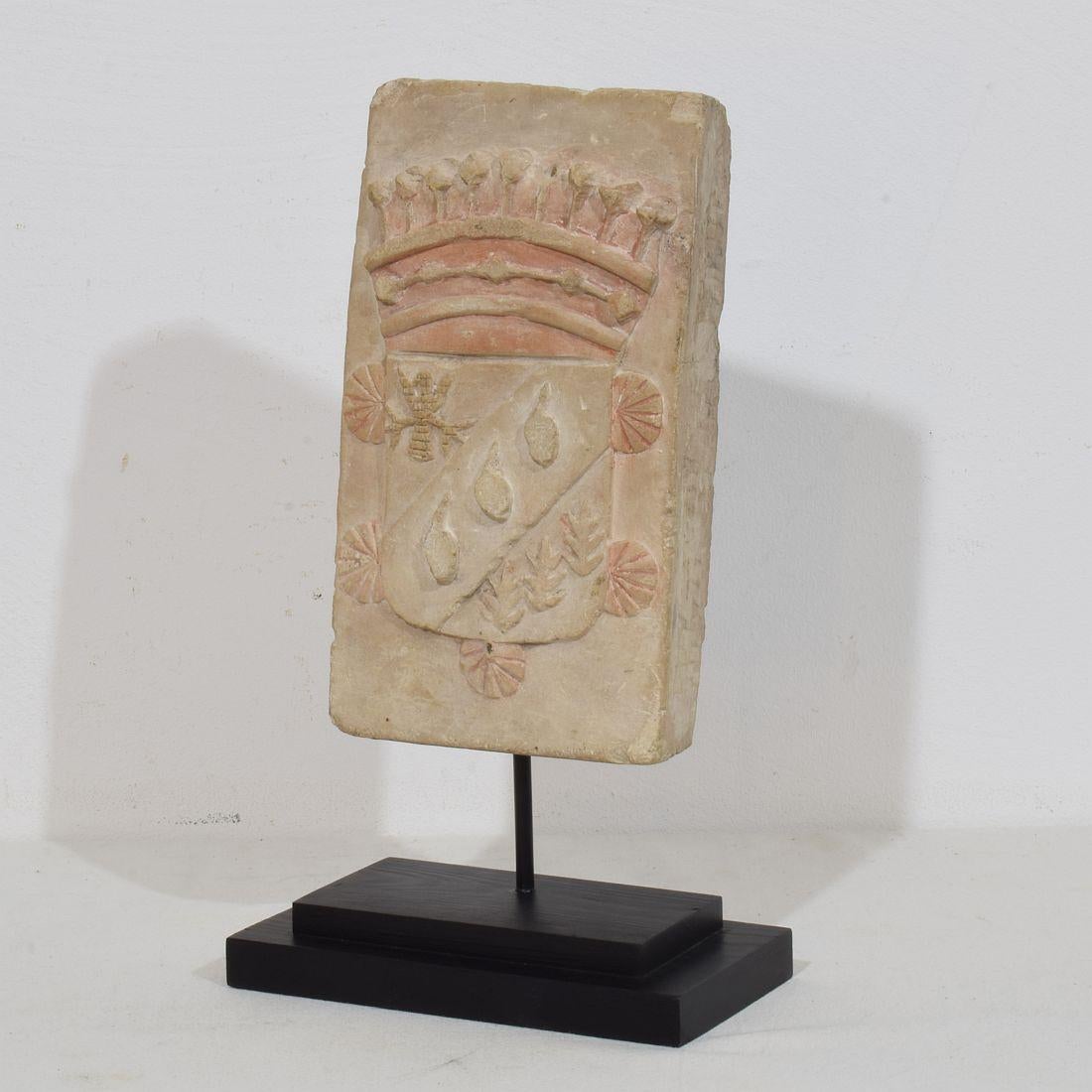 Very beautiful hand carved limestone coat of arms. Great weathered patina and traces of old color.
France, circa 1750. Weathered.
Measurement here below is inclusive the wooden base.
H:22,5-31cm  W:17cm D:9cm 