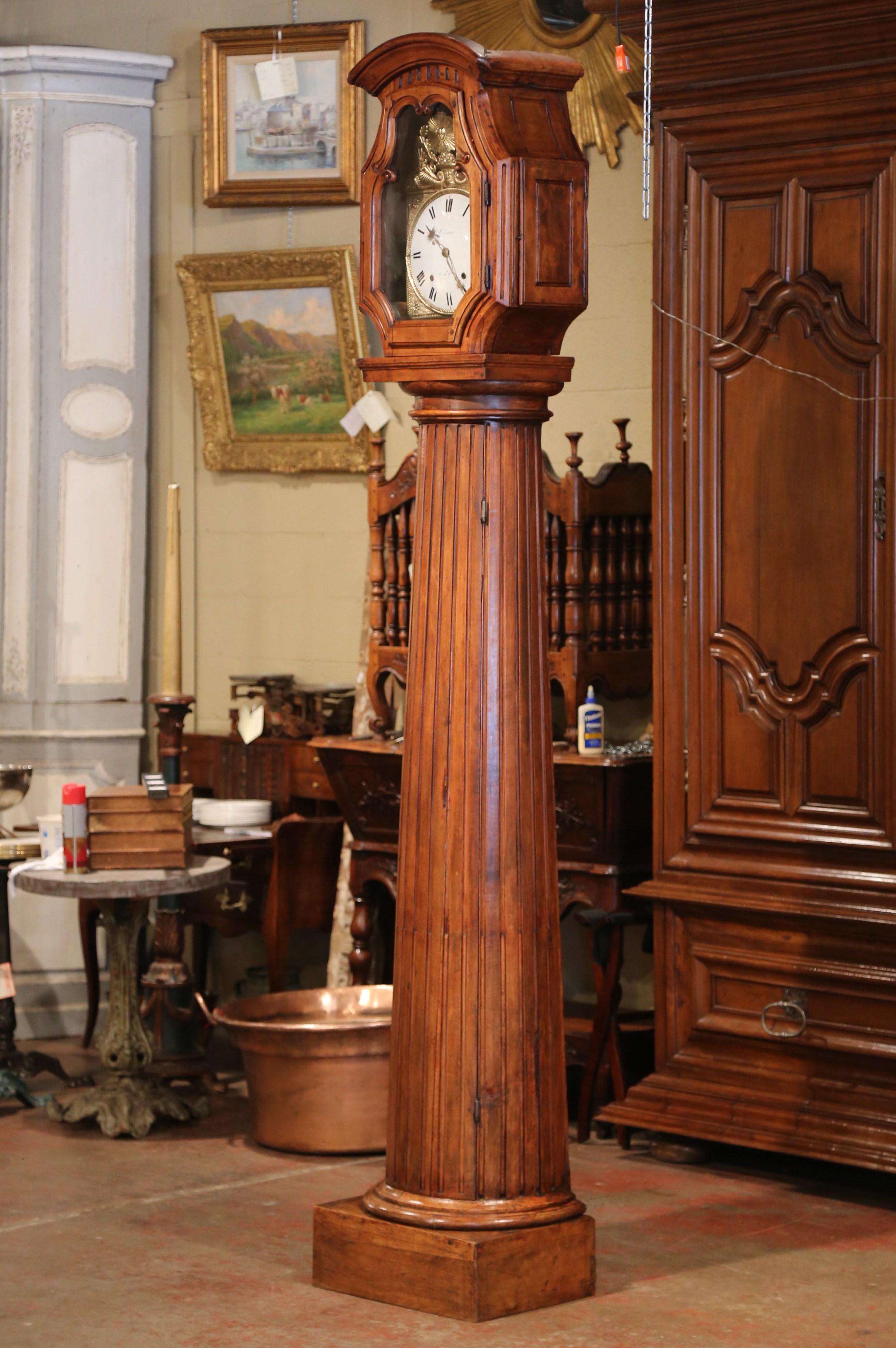 Decorate an entry or dining room with this unique, antique, long case clock. Crafted in Lyon, France, circa 1760, and shaped as a carved spline column, the tall time keeper sits on a sturdy, square plinth. The clock is decorated with a bonnet top,