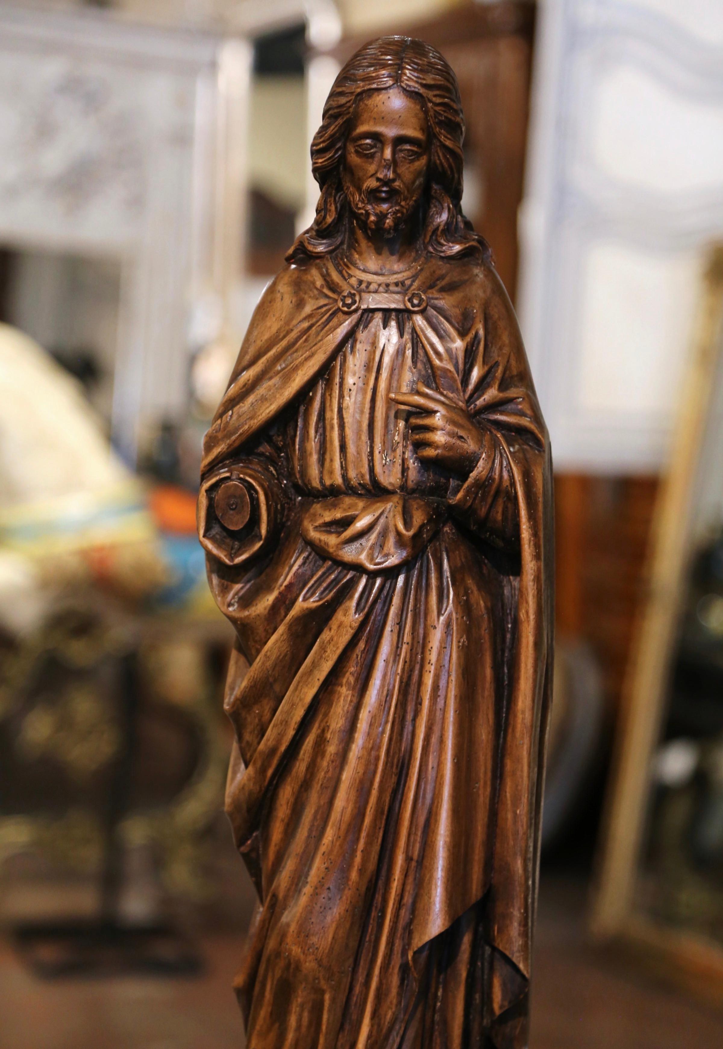 This beautiful antique Christ statue was hand carved in France, circa 1780. Standing on a octagonal integral base, the sculpture depicts our Lord Jesus Christ, a fine example of ecclesiastical art from that period. The figure is depicted with