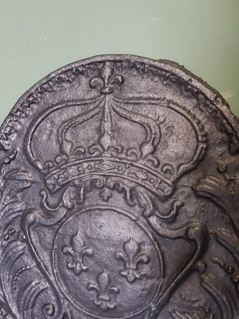 Antique French cast iron fireback with the family arms of Huis Bourbon, with the French lily, crown and palm branches on both sides, this is in a good but used condition. Originating from the 18th century.

The measurements:
Depth 2 cm/ 0.7