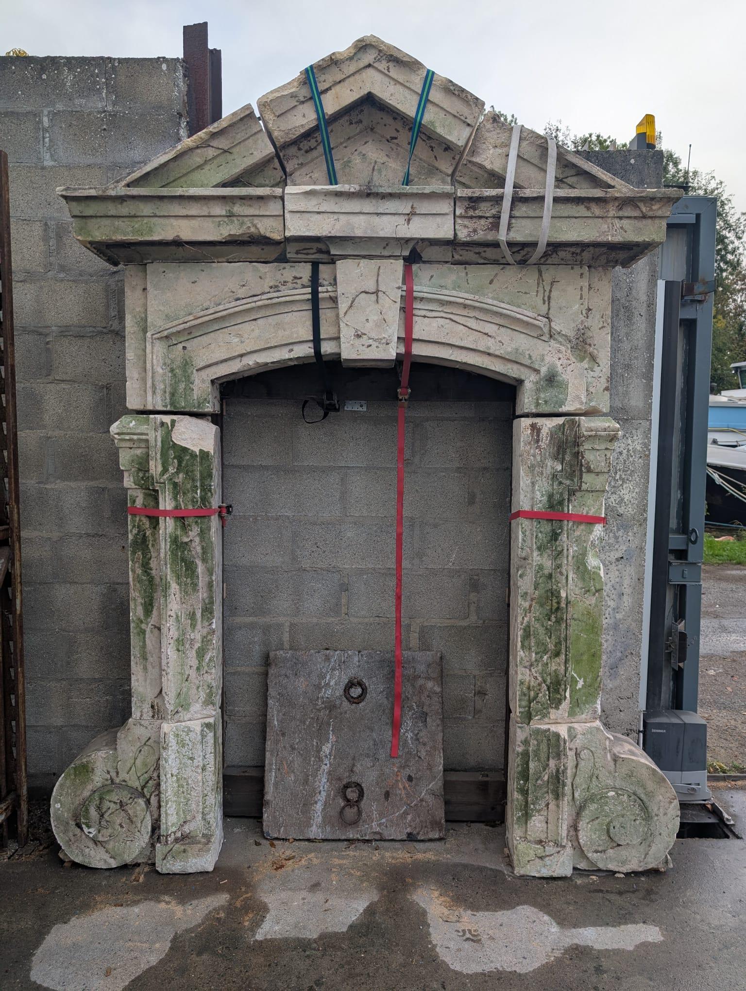 Magnificent architectural limestone arch originating from an 18th-century French château, carved from white limestone (pierre calcaire blanche). This grand piece features a triangular pediment resting on a richly molded arched opening, supported by