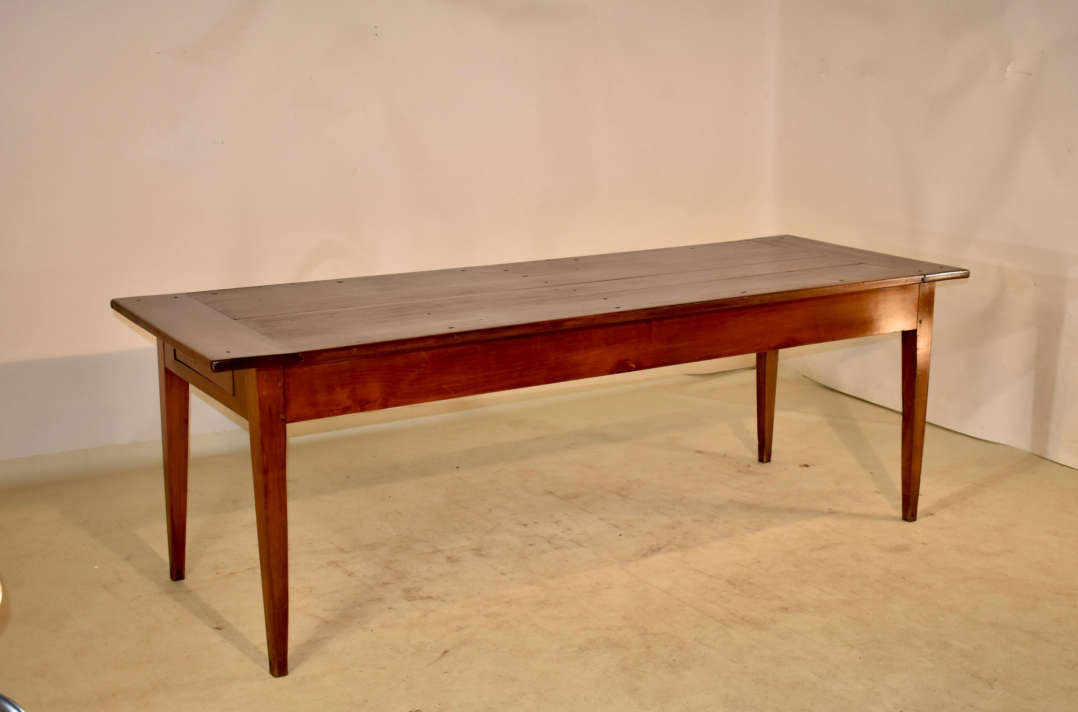 Late 18th century cherry farm table from France with a banded top, which has hand cut nail and pegged construction over a simple apron which contains a single drawer. The table is supported on hand tapered legs. The apron measures 23 inches in