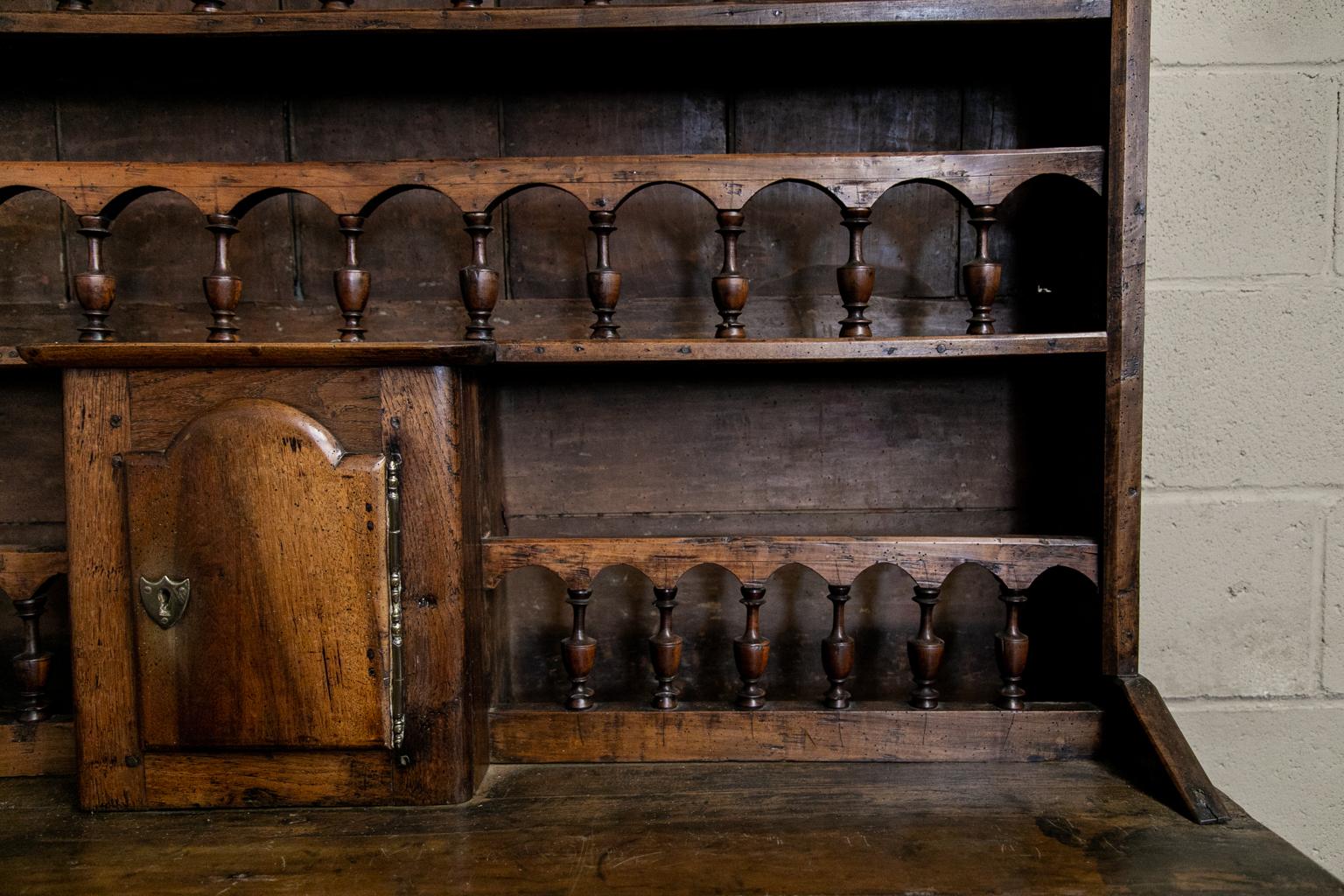 18th century cherry French Vassilier made of cherry and oak. The top has four shelves with baluster guard rails. It has a door in the center of the top half. The bottom section has three drawers and two doors with original brass engraved escutcheons