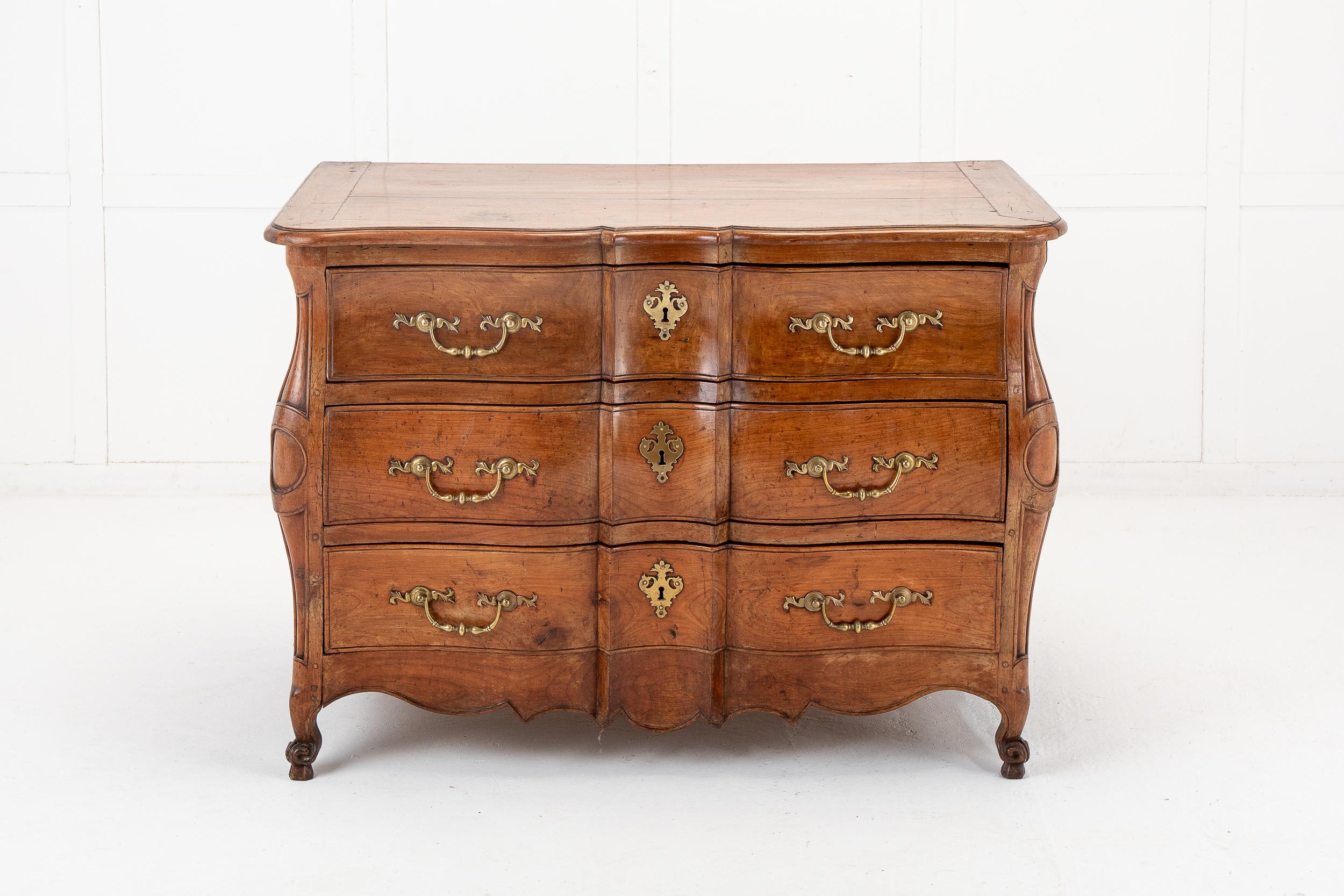A beautiful 18th Century French cherrywood bombe commode of superb quality, with serpentine form, and all its original metal work. The top with solid planks and moulded edging conforms to the shape below. Having three large drawers with drop bar