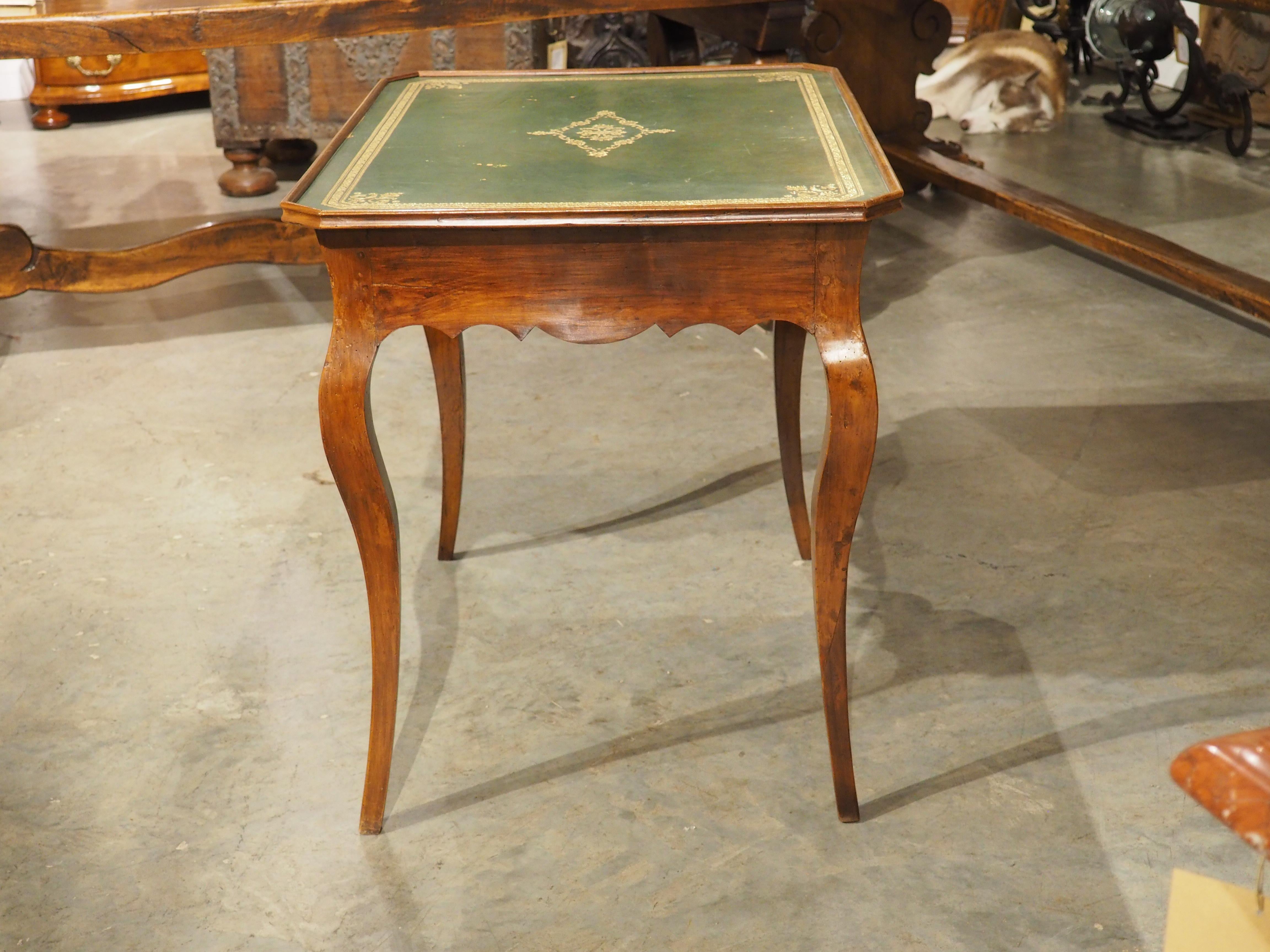 Sculptée à la main dans du bois de cerisier sous le règne de Louis XV (milieu et fin des années 1700), cette table d'apparat est dotée d'un plateau en cuir vert estampé. Une table d'apparat n'était pas conçue pour un usage quotidien, mais plutôt une