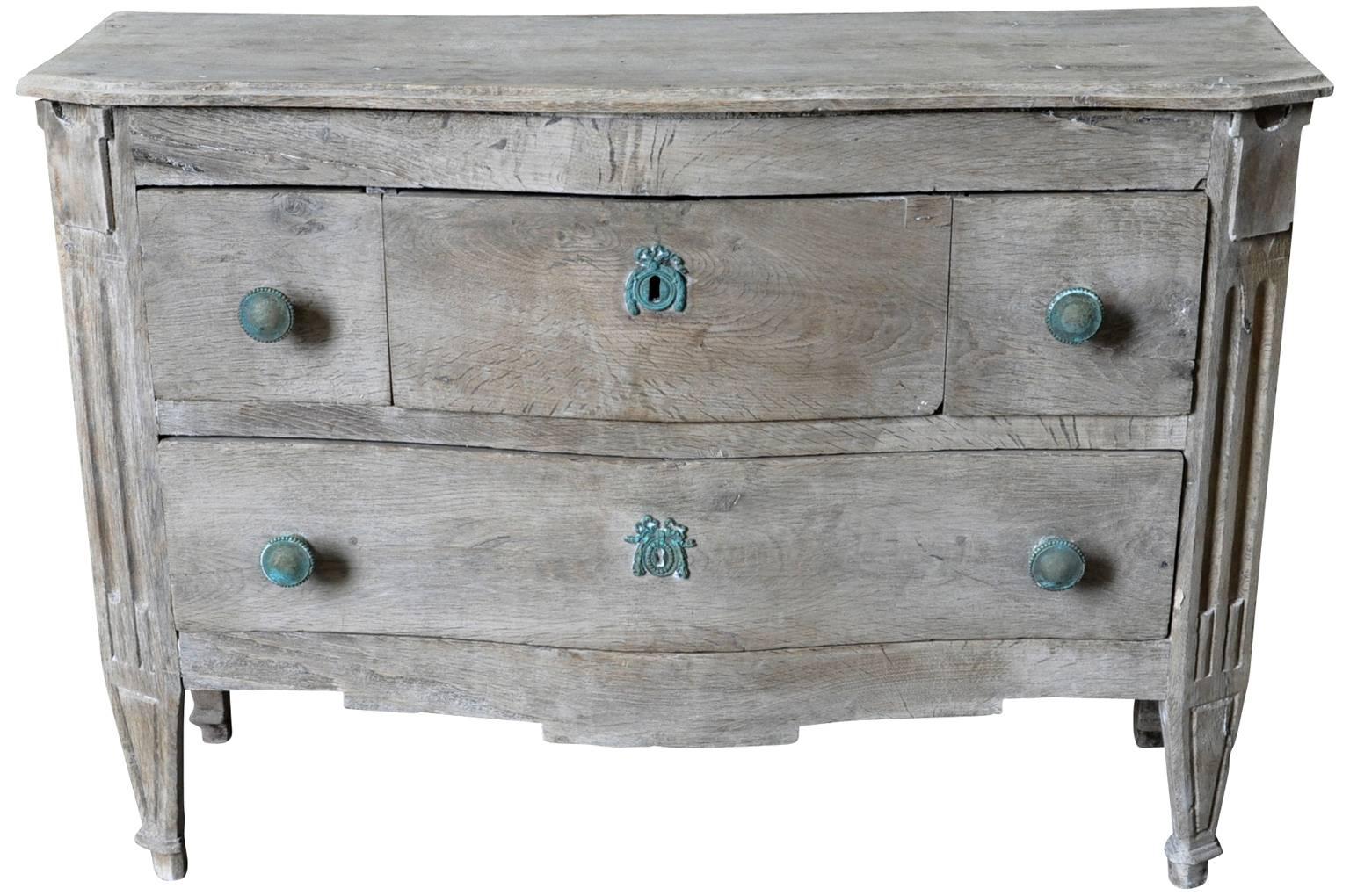 A very rare and charming mid-18th century transition Louis XV - Louis XVI commode from the Provence region of France. Beautifully constructed from washed chestnut with four drawers and bronze hardware. Its unusually diminutive size makes this indeed