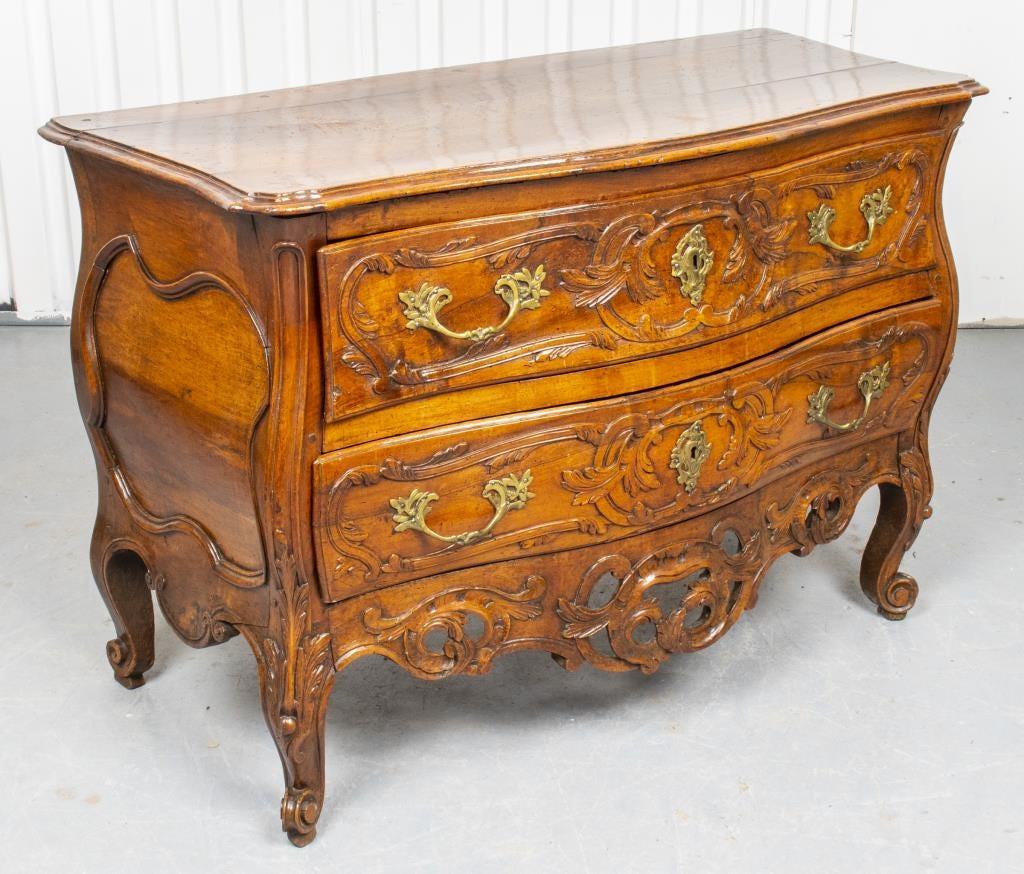 Louis XV Provincial light walnut commode from Arles, France, mid 18th century, the chest with serpentine top, two long drawers with brass foliate form pull handles, compartment dividers and later fabric lined, the case with rocaille carved details