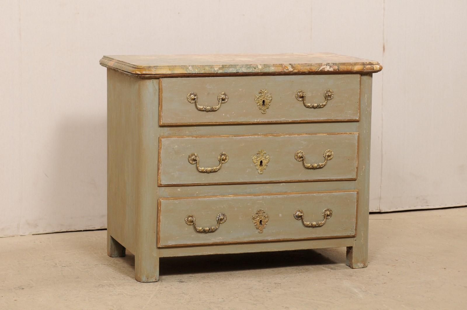 An 18th century French commode with an unusually colored and quite beautiful marble top. This antique chest from France has a rectangular-shaped marble top, over the wooden case which houses three full-sized, graduated doors. Drawers are flanked