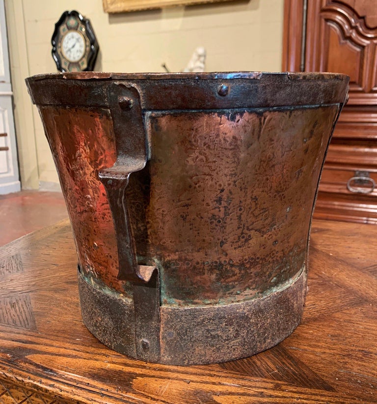 This antique grain measuring recipient was crafted in France, circa 1780. The copper bucket features forged nailed iron strapping with nails embellished with a side handle. The measuring tool is in good condition, and has a rich copper polished