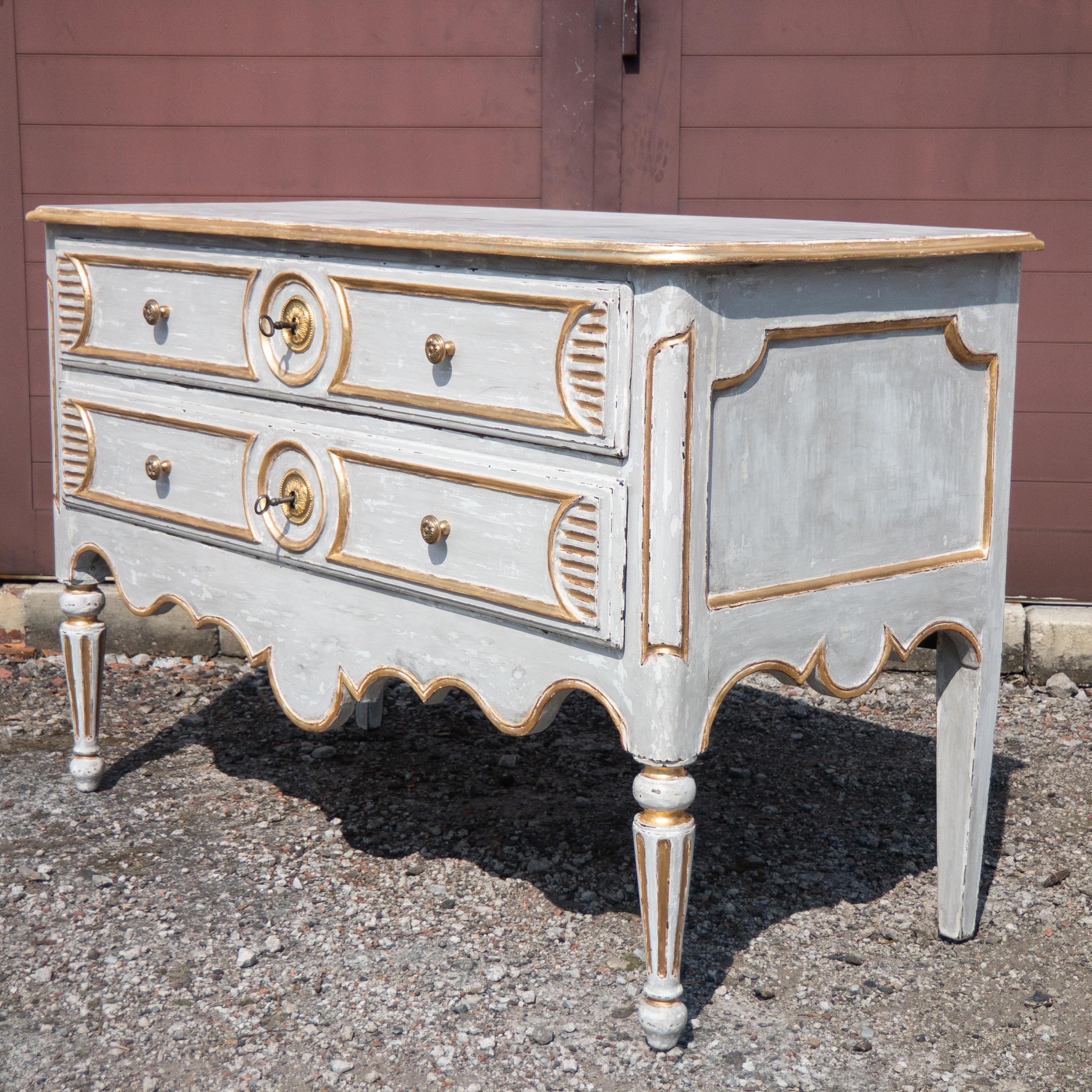 This extraordinary antique provincial commode or chest of drawers is made from Oak wood in France at the end of the 18th Century. The chest has two drawers, each with a separate working lock, and brass fittings. The commode has a beautiful grey and