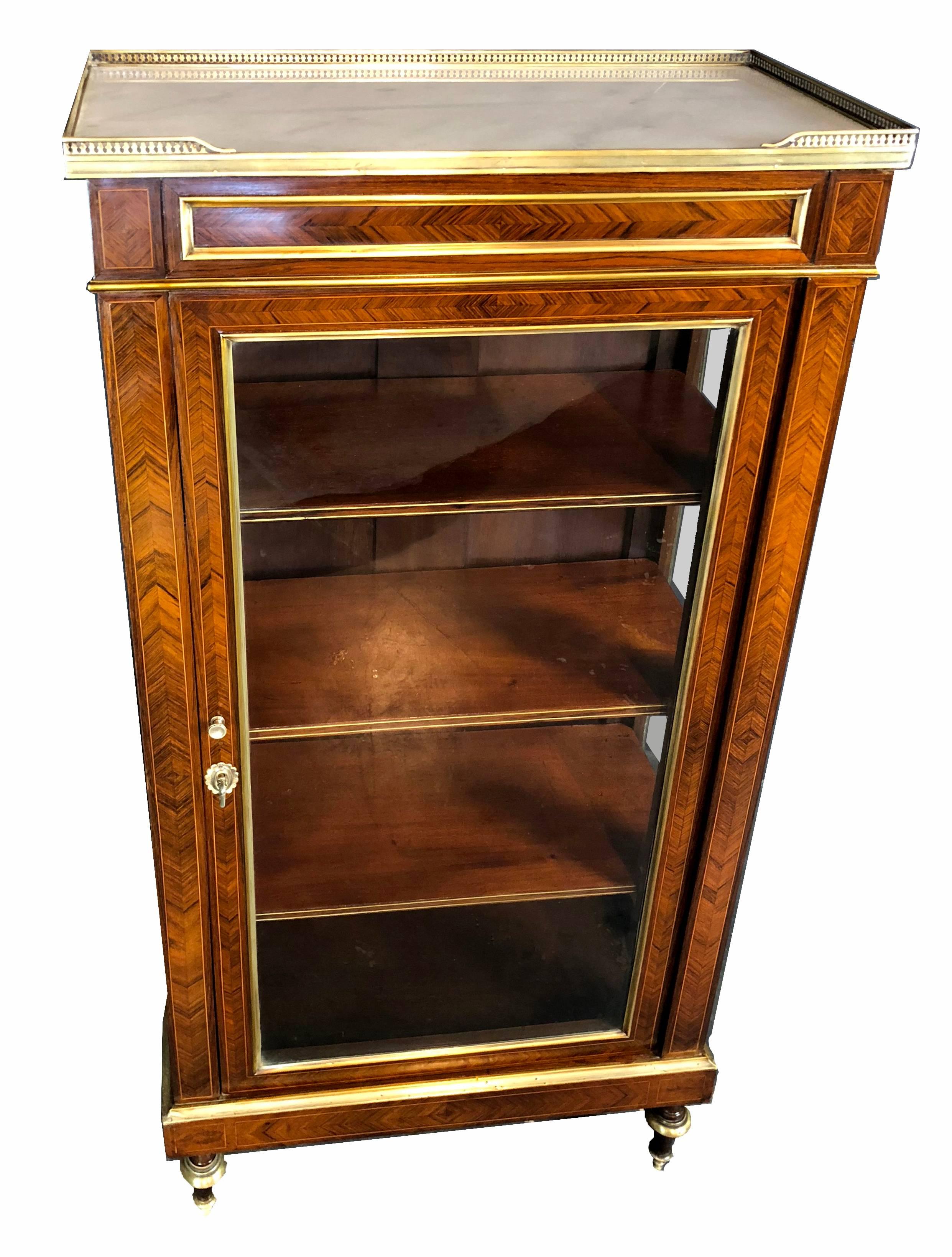 Fine and rare end of 18th century period French Directoire petite vitrine with exquisite herringbone kingwood veneers with line inlays, adorned by gilt bronze mouldings throughout. The top with characteristic white marble is surrounded by a brass