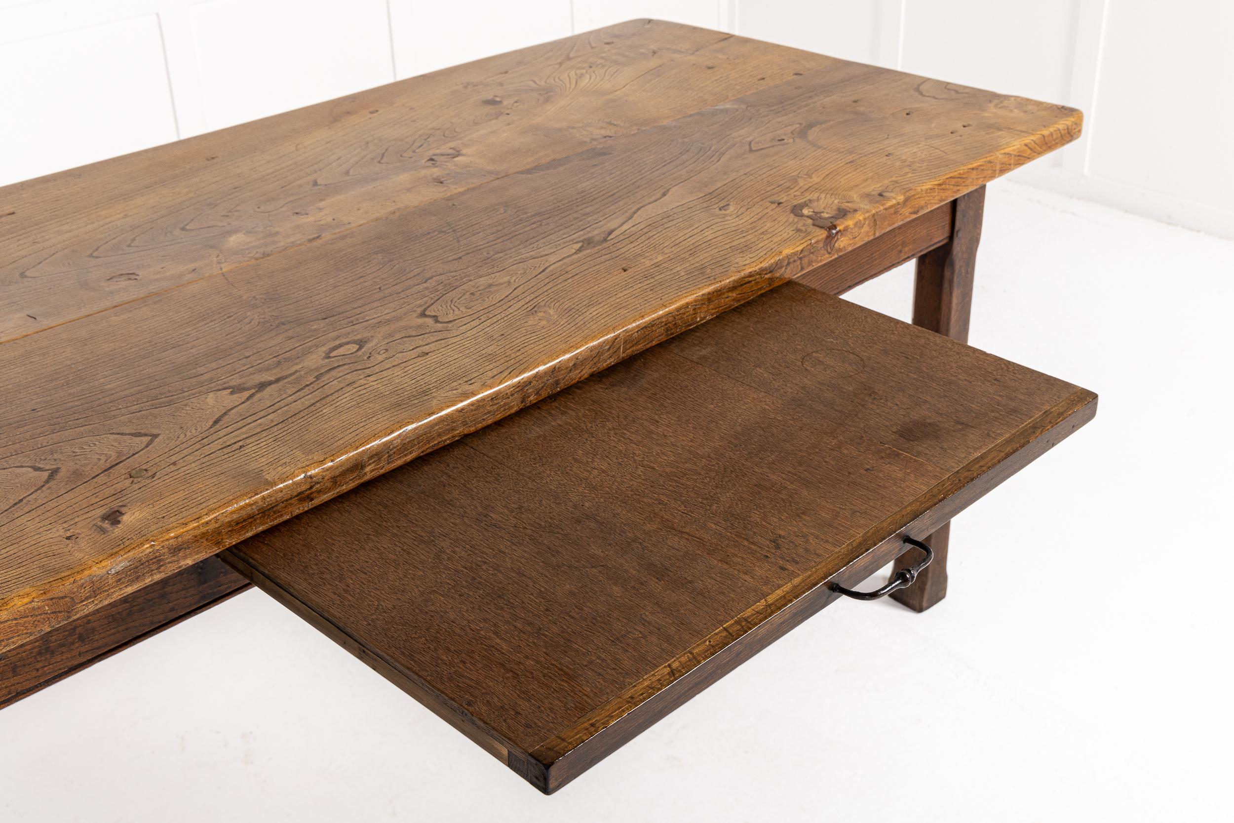 A Large Scale 18th Century French Farmhouse Table with Elm Top and Oak Base.

This table has a particularly large overhanging elm top with lovely figure and good faded colour. It sits on an oak base with a simple frieze which has a bread slide to
