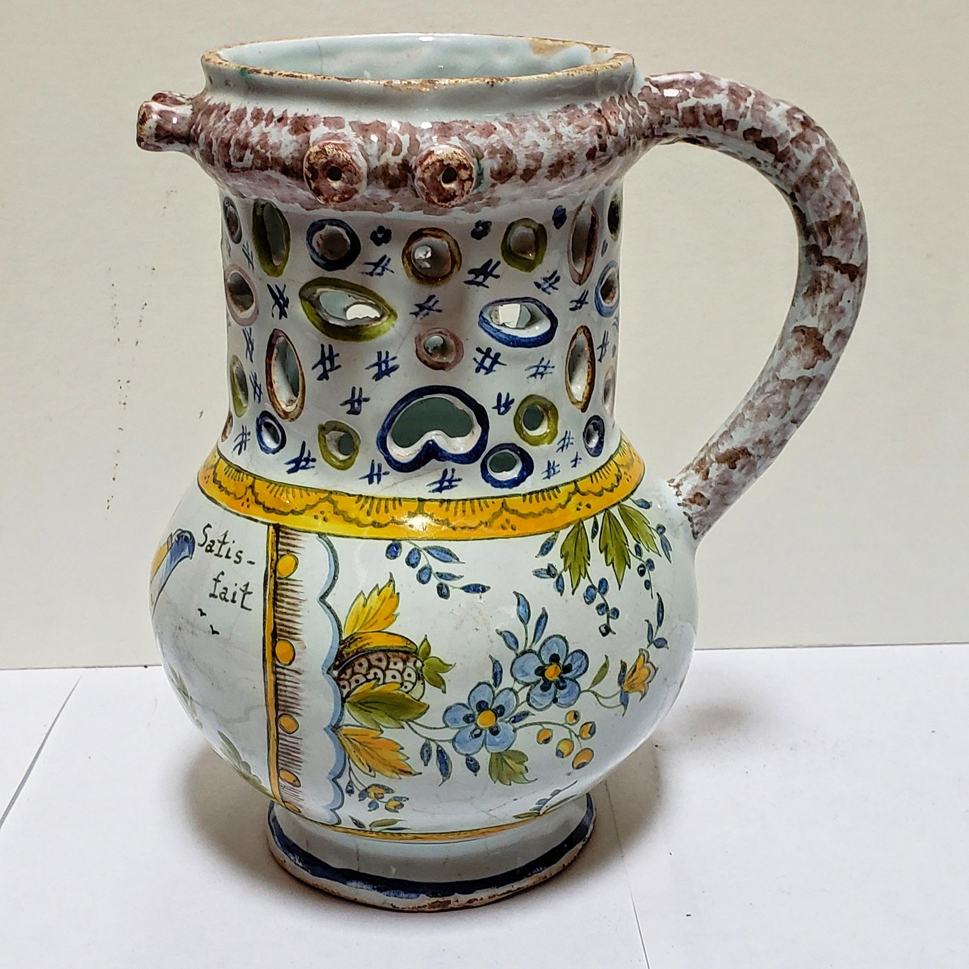 A rare and colorful French faience hand-thrown pottery “pichet trompeur” from the town of Nevers celebrating the French Revolution. The puzzle, of course, is to figure out how to drink from a pitcher with over 3 dozen holes and 6 spouts. It is very