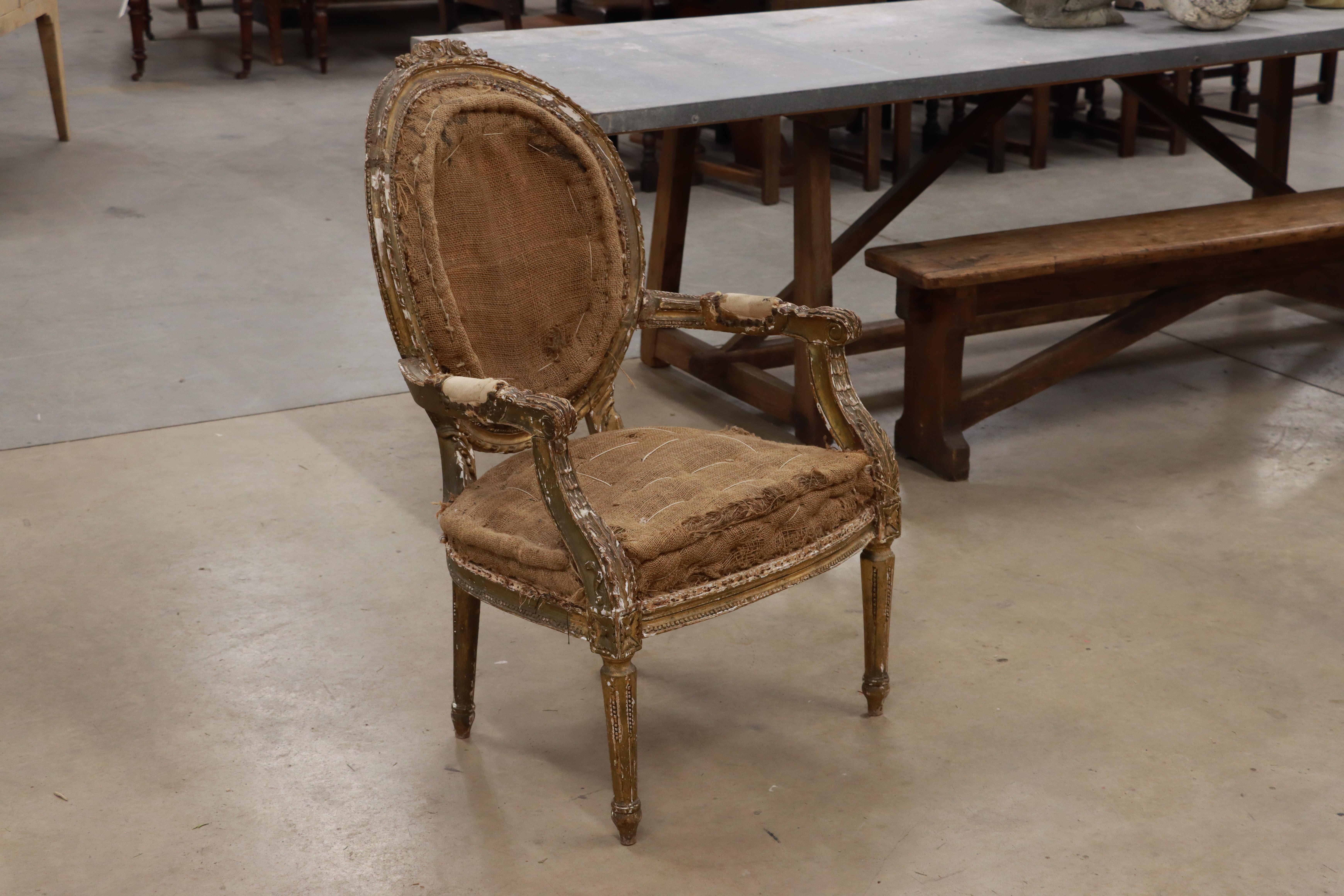 Französischer Fauteuil-Stuhl aus dem späten 18. Jahrhundert (Louis VXI). Er hat eine ovale Kamee-Rückseite mit einer Kartusche auf der Oberseite, mit nach unten gebogenen Armen und geriffelten Beinen. Es hat noch sichtbare Reste der ursprünglichen