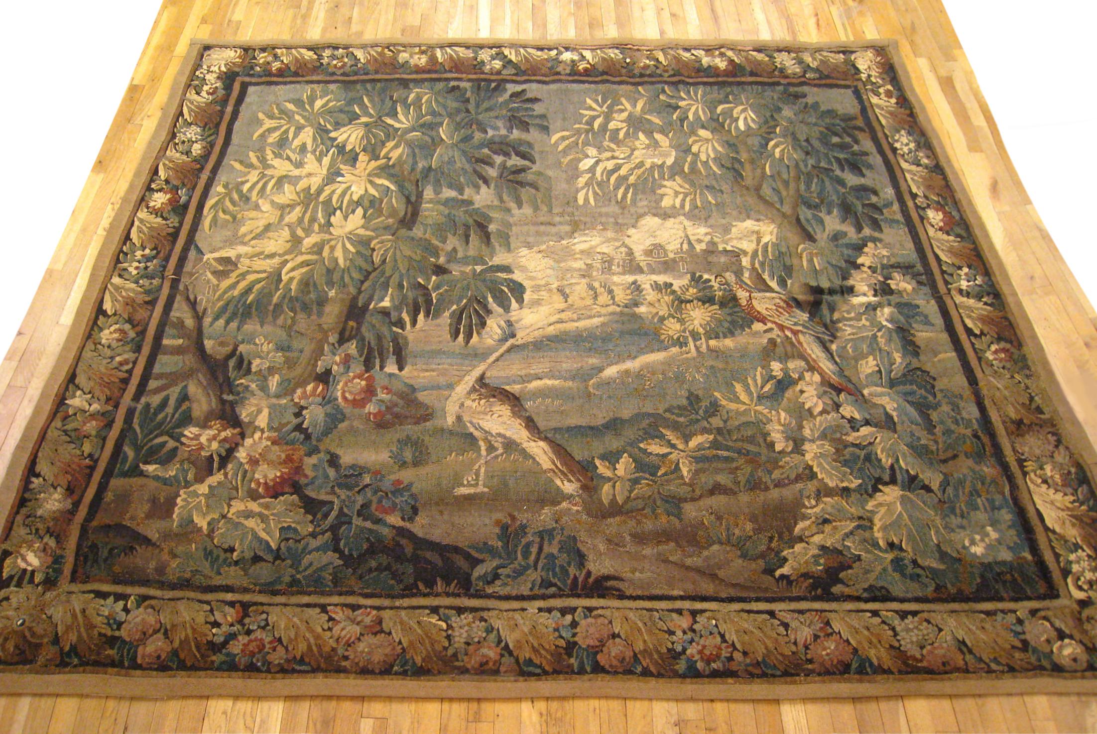 An antique 18th century French Felletin verdure landscape tapestry, size 8'10 H x 9'7 W. This handwoven antique wall hanging features two exotic birds at centre in the midst of greenery, trees, flowers, and acanthus plants. The central scene is