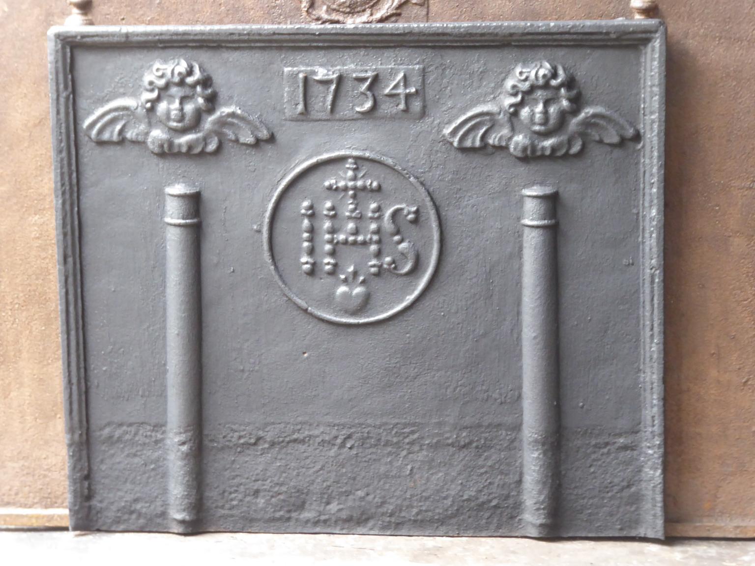 18th century Louis XIV French fireback with pillars, IHS monogram, angels and the date of production 1734.

The monogram IHS stands for Iesus Hominum Salvator (Jesus the Savior of Humanity) or In Hoc Signo (In this sign will you win). The pillars