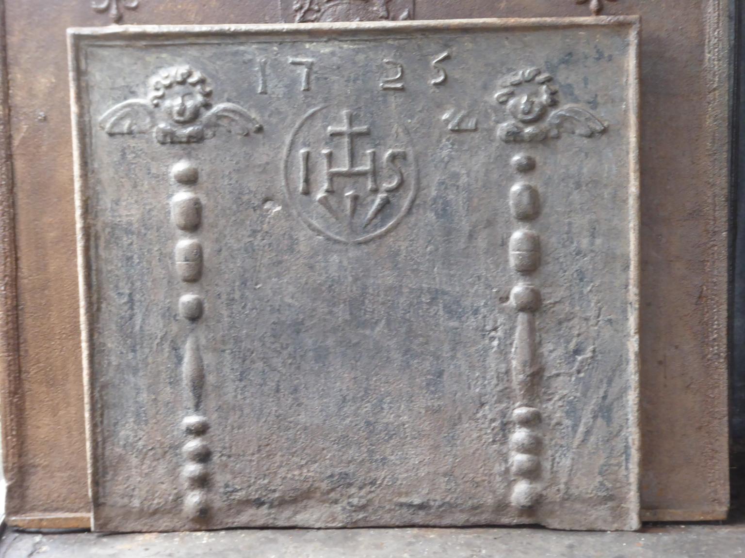 18th century Louis XV French fireback with pillars topped with angels, an IHS monogram, and the date of production 1725.

The monogram IHS stands for Iesus Hominum Salvator (Jesus the Savior of Humanity) or In Hoc Signo (In this sign will you win).