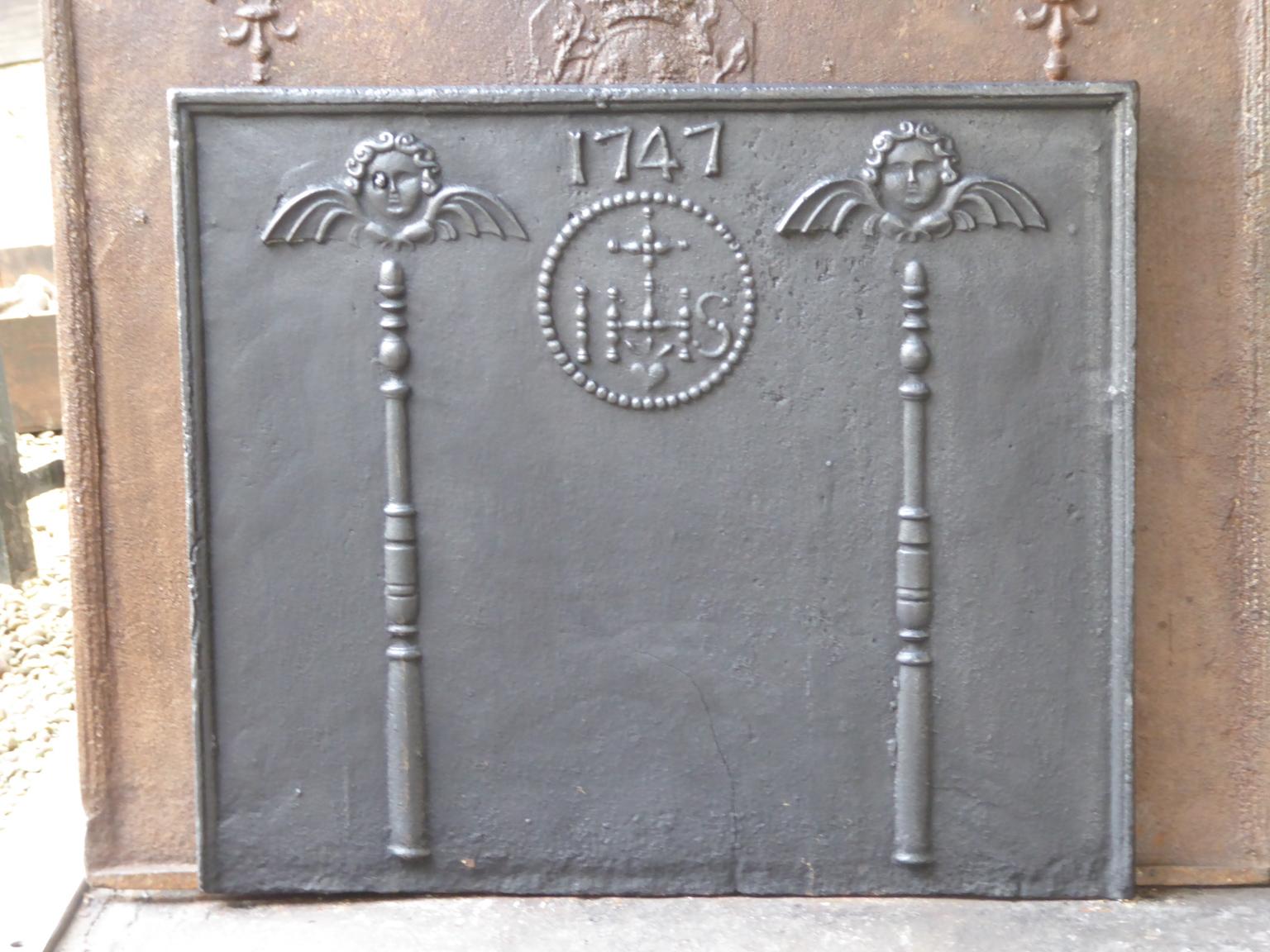 18th century Louis XV French fireback with pillars topped with angels, an IHS monogram, and the date of production 1747.

The monogram IHS stands for Iesus Hominum Salvator (Jesus the Savior of Humanity) or In Hoc Signo (In this sign will you win).